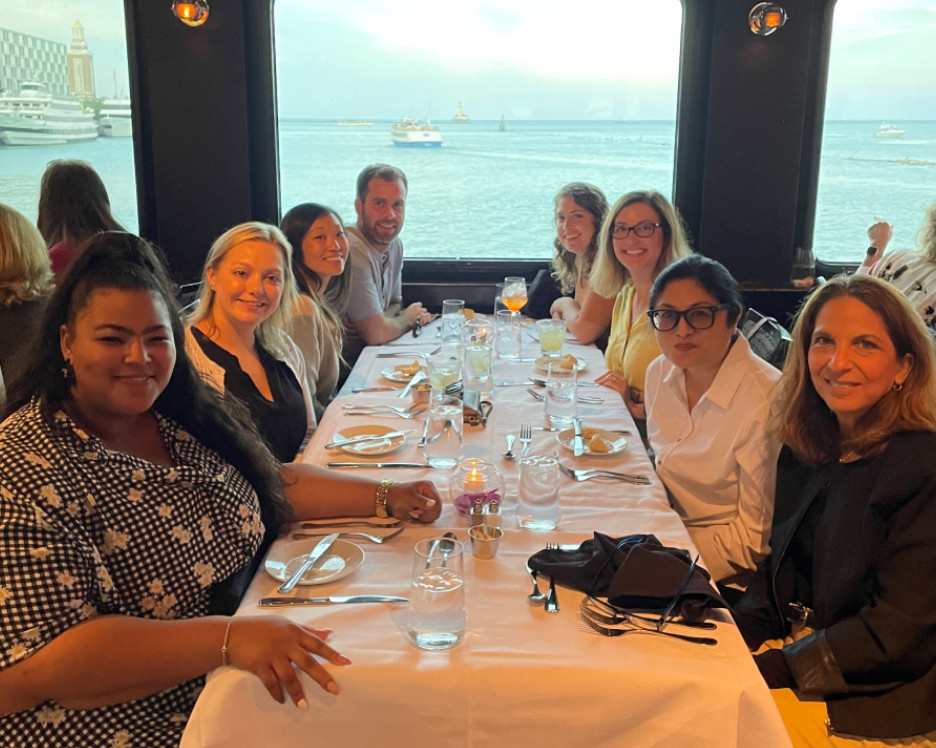 Members of the Ragan Communications team sharing dinner at a long table