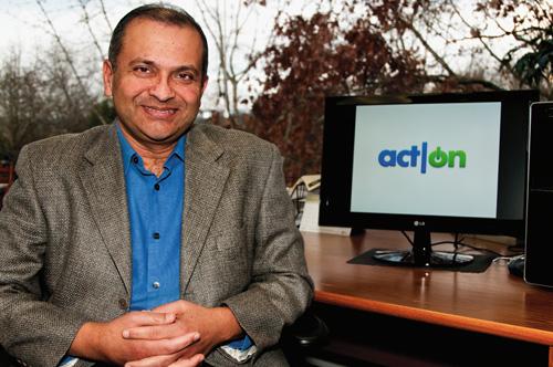 Raghu Raghavan seated beside a monitor displaying the Act-On logo
