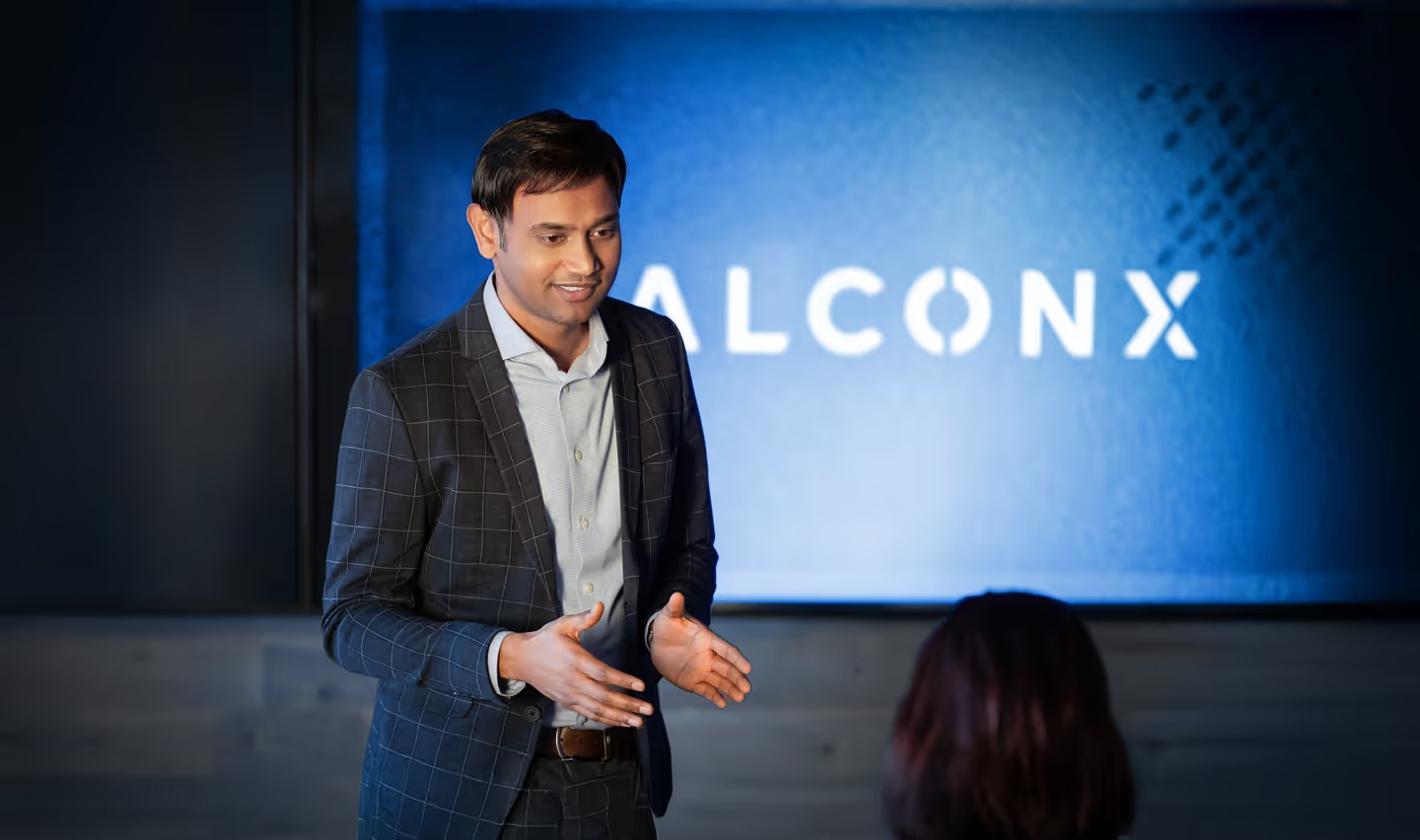 Raghu Yarlagadda speaking with an attendee at a FalconX event