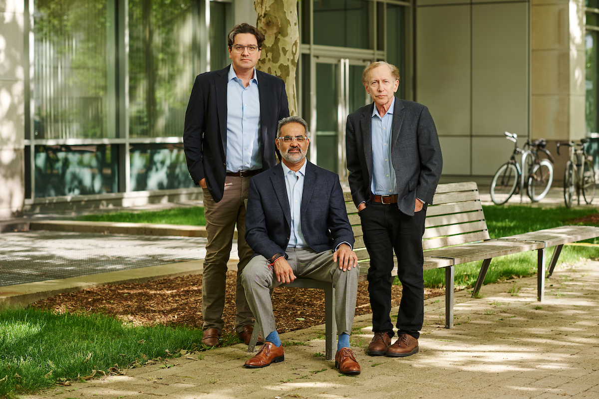 Syntis co-founders Giovanni Traverso, Rahul Dhanda and Robert Langer outdoors beside a bench