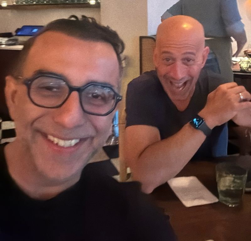 Rahul Khosla, left, and Sitecore CEO Eric Stine smiling together at a restaurant table
