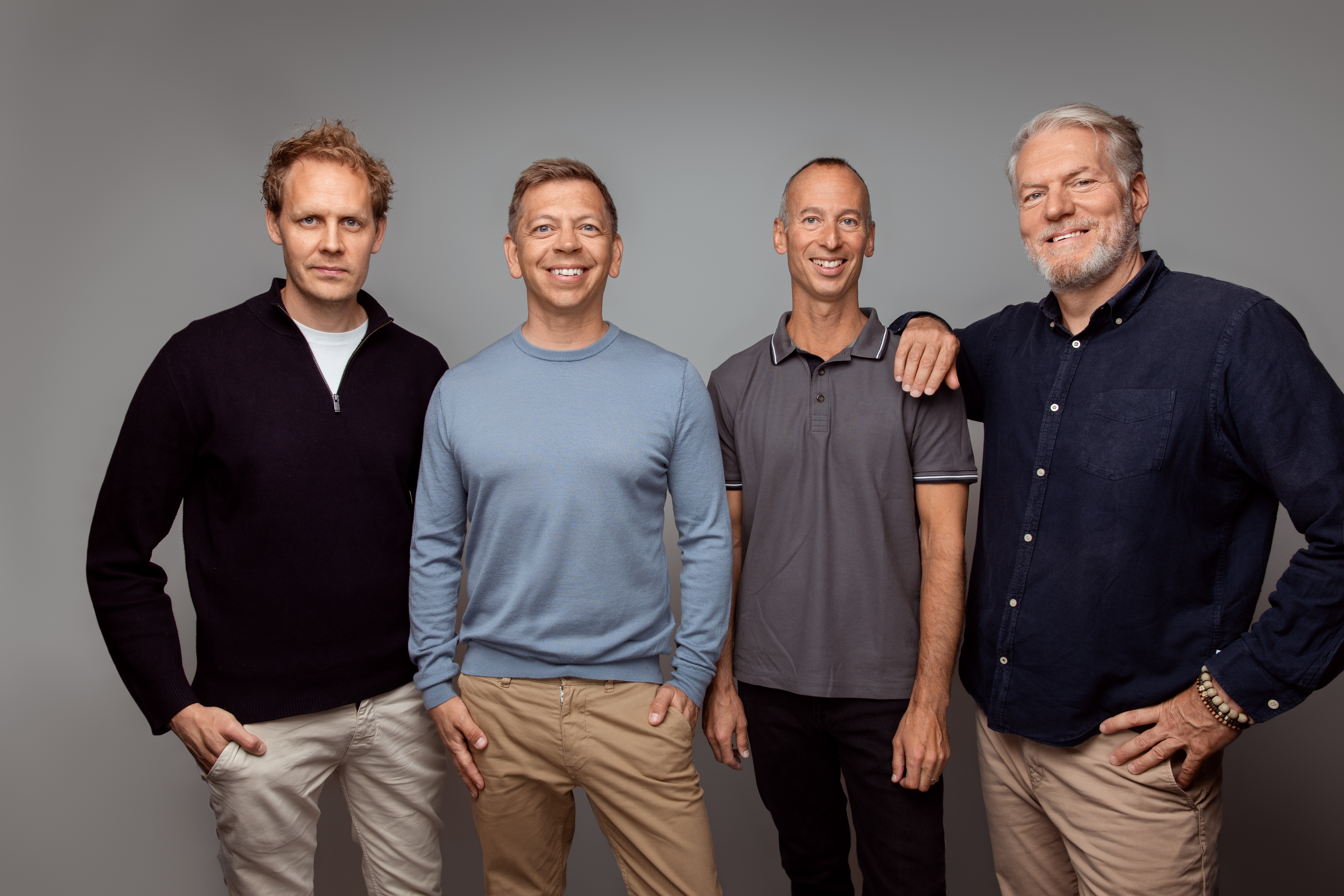 Four members of Rainmaking’s partner group in a studio press portrait