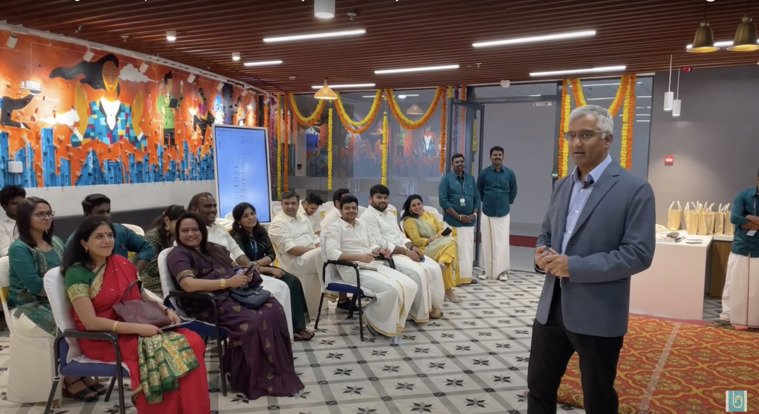 Raj Krishnamurthy speaking to seated colleagues at the decorated Freespace office in Coimbatore