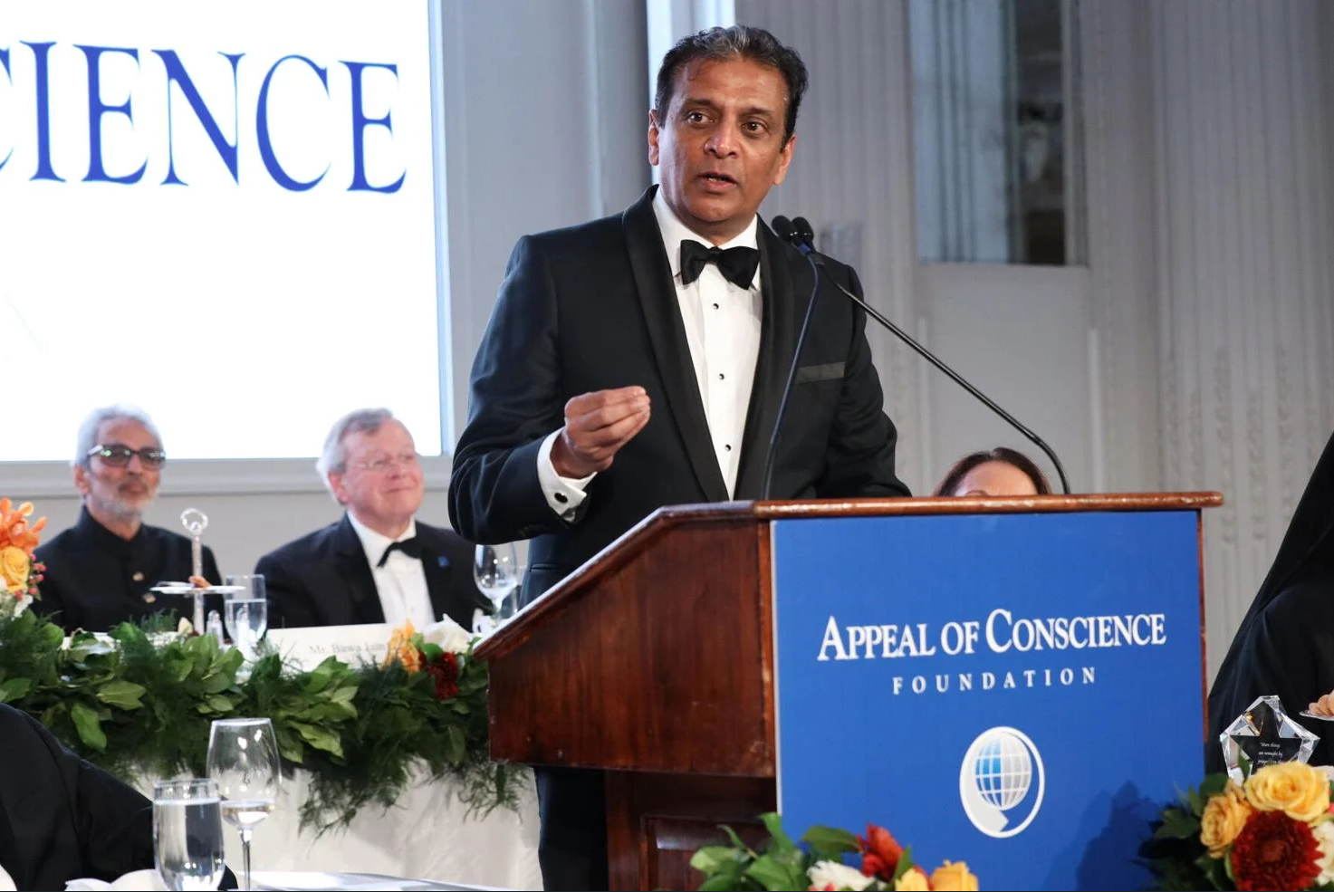 Raj Subramaniam speaking at a lectern at the Appeal of Conscience Foundation gala