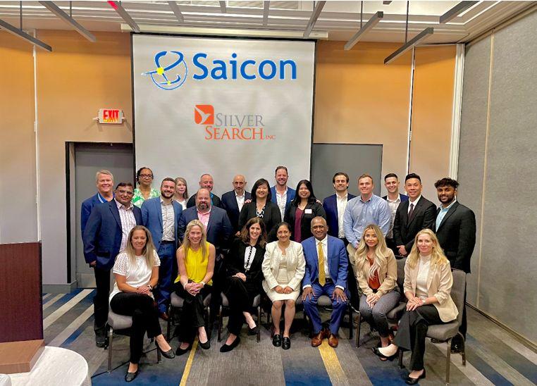 Ramesh Lokre seated with the Saicon and SilverSearch teams beneath a banner displaying both company names