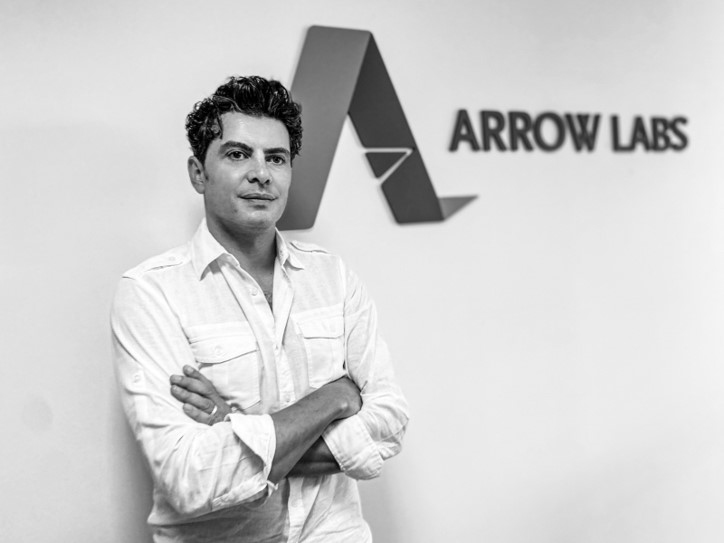 Rami Darwish standing with his arms folded in front of the Arrow Labs office sign