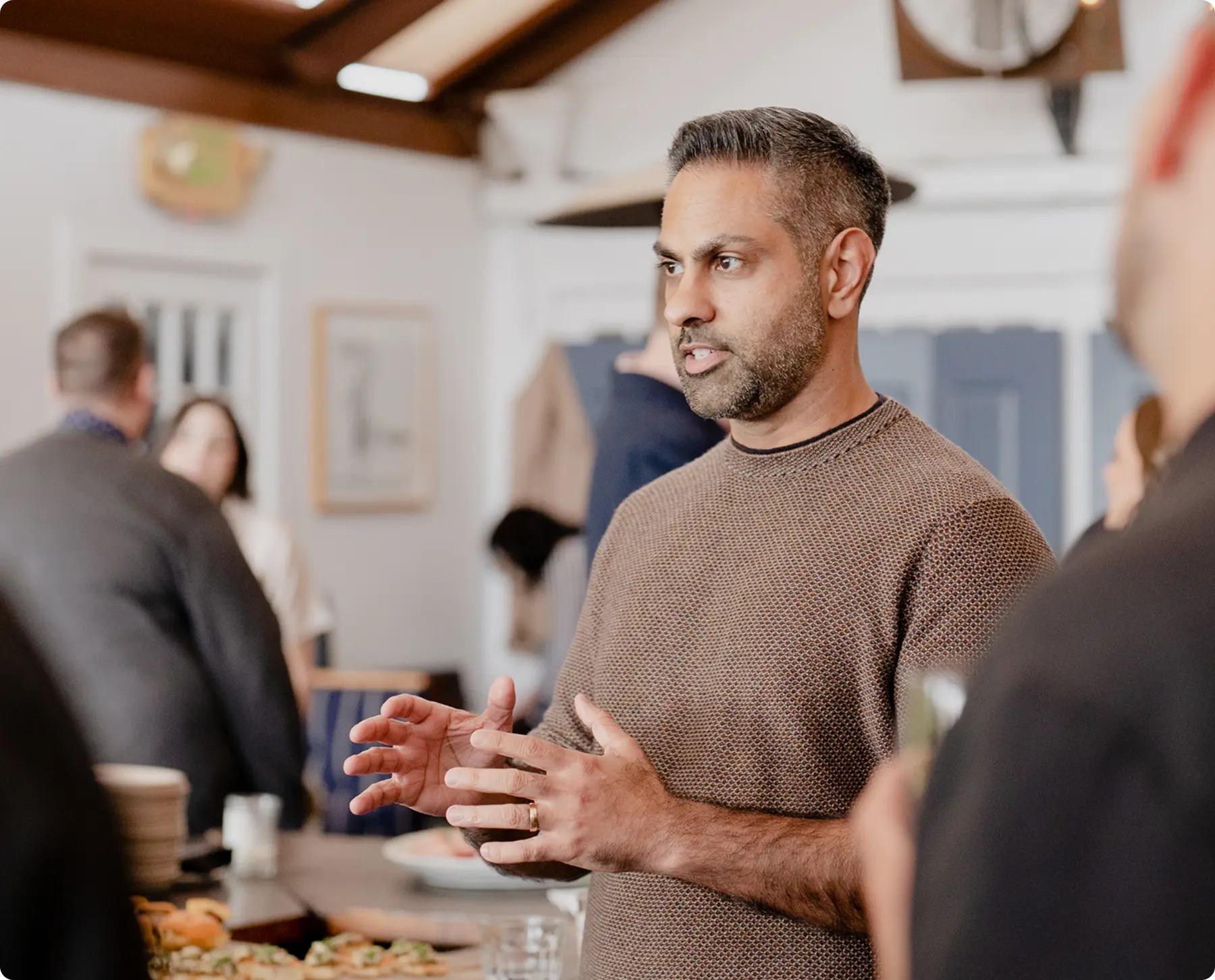 Ramit Sethi speaking with guests at an event