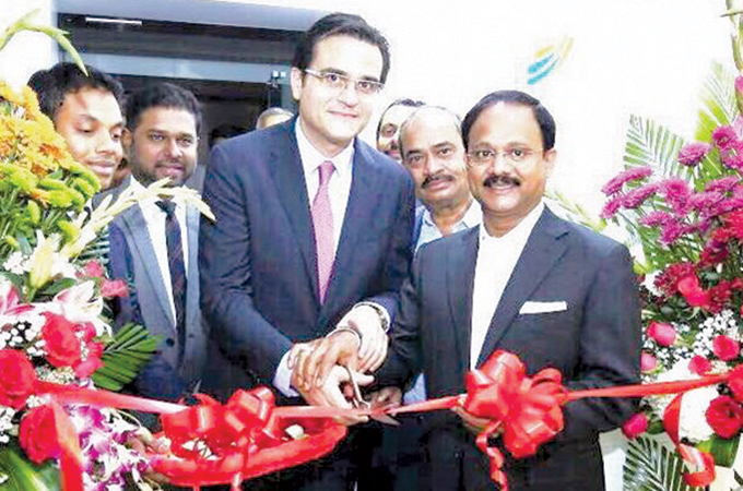 Ramzi Al-Qassab and Dr Siddeek Ahmed cutting a red ribbon at an ITL World corporate office opening