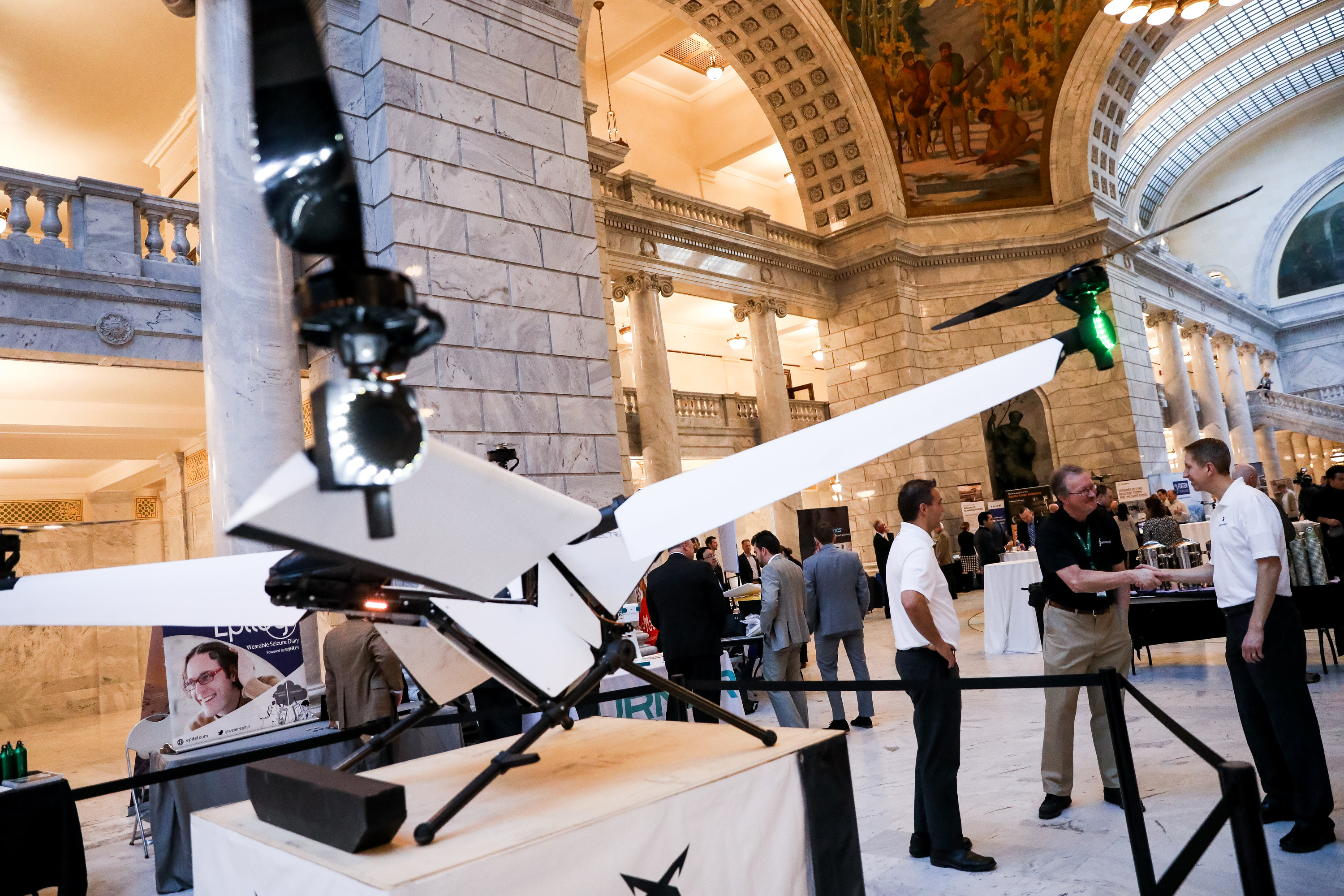 Randall Mills talks with ElectraFly co-founders beside a personal flying machine in the Utah State Capitol rotunda