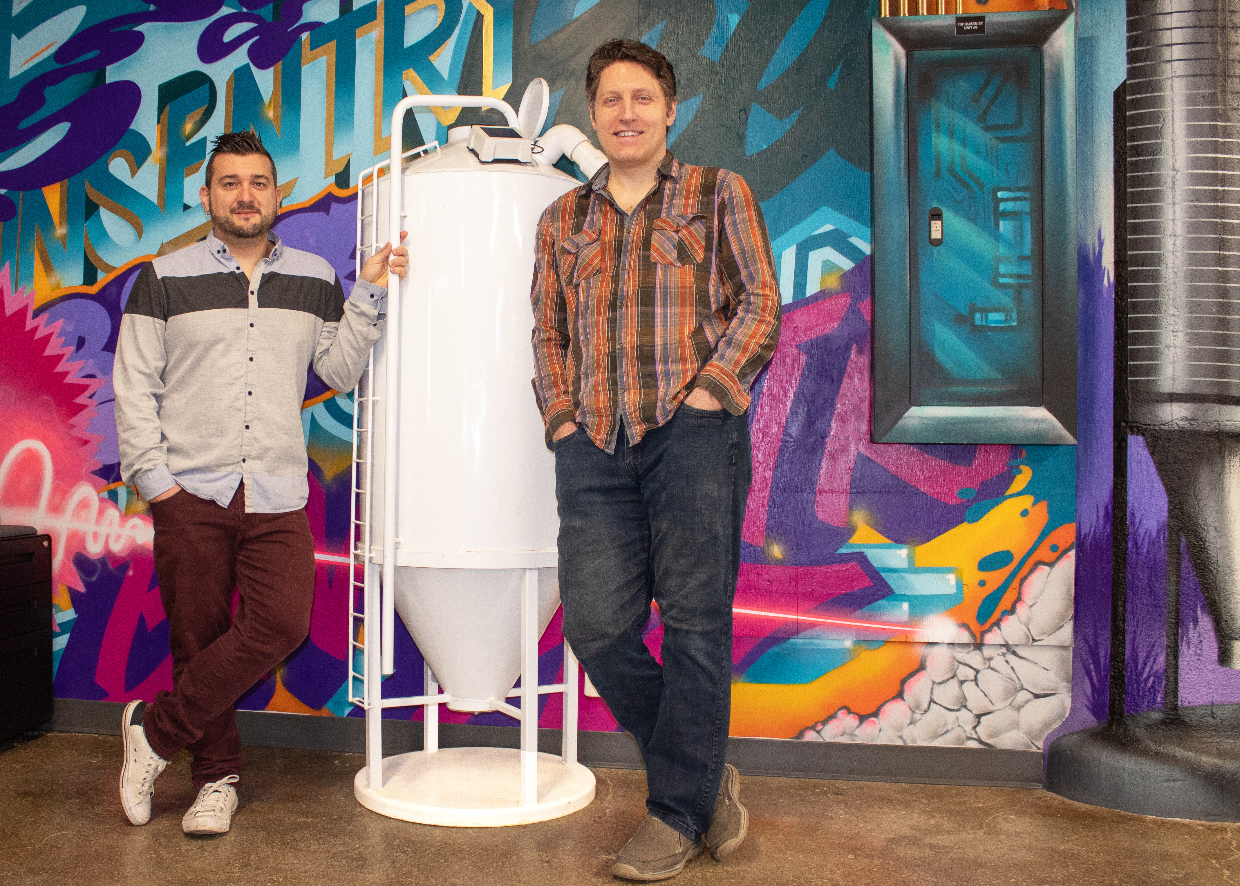 Randall Schwartzentruber, left, and Nathan Hoel beside a white feed-bin display