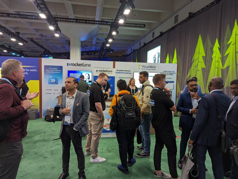 Rao Adavikolanu speaking with attendees at Rocketlane's Dreamforce 2024 booth