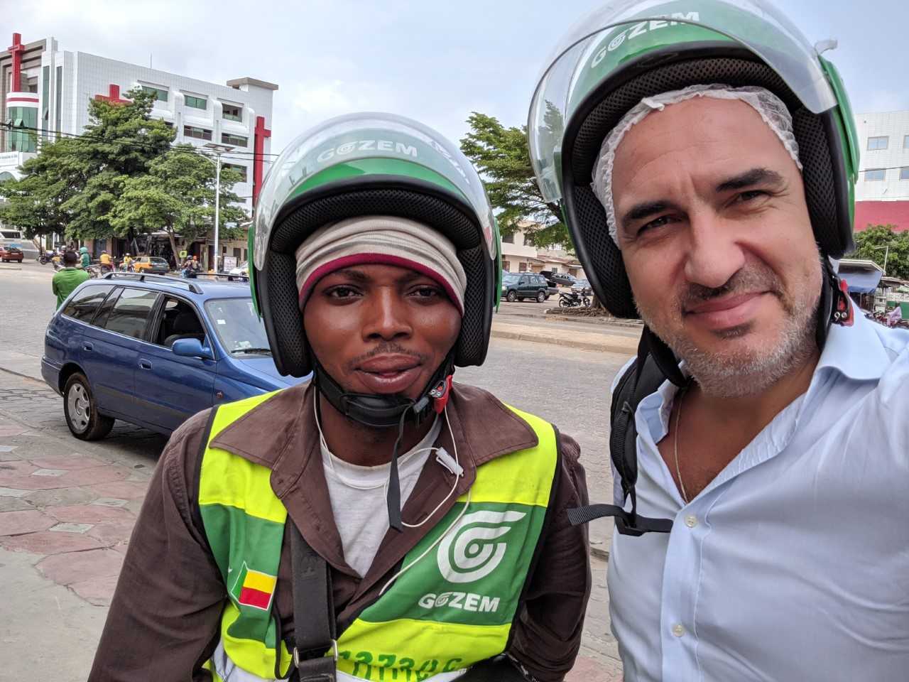 Raphael Dana, right, wearing a Gozem helmet beside a Gozem driver in Benin