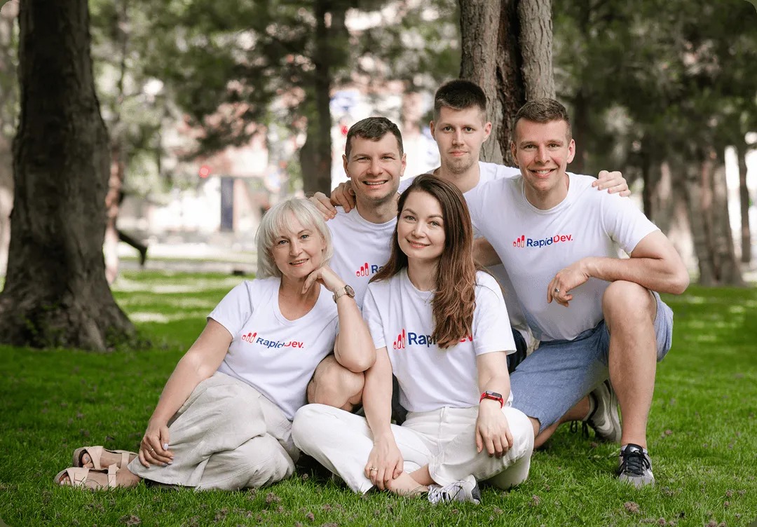 Five RapidDev team members wearing company shirts outdoors