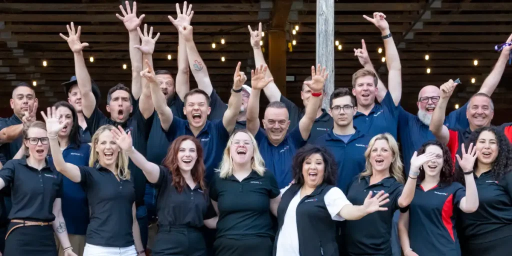 RapidSOS team members in company shirts posing together with raised hands
