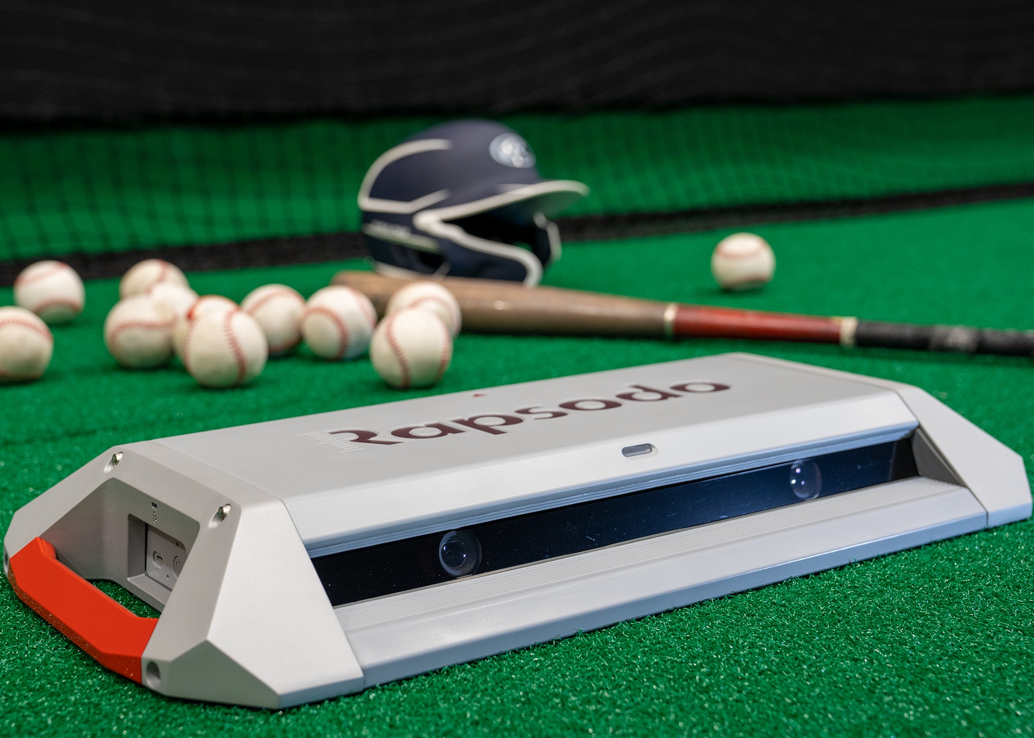 PRO 3.0 monitor on baseball practice turf beside a bat, helmet and baseballs