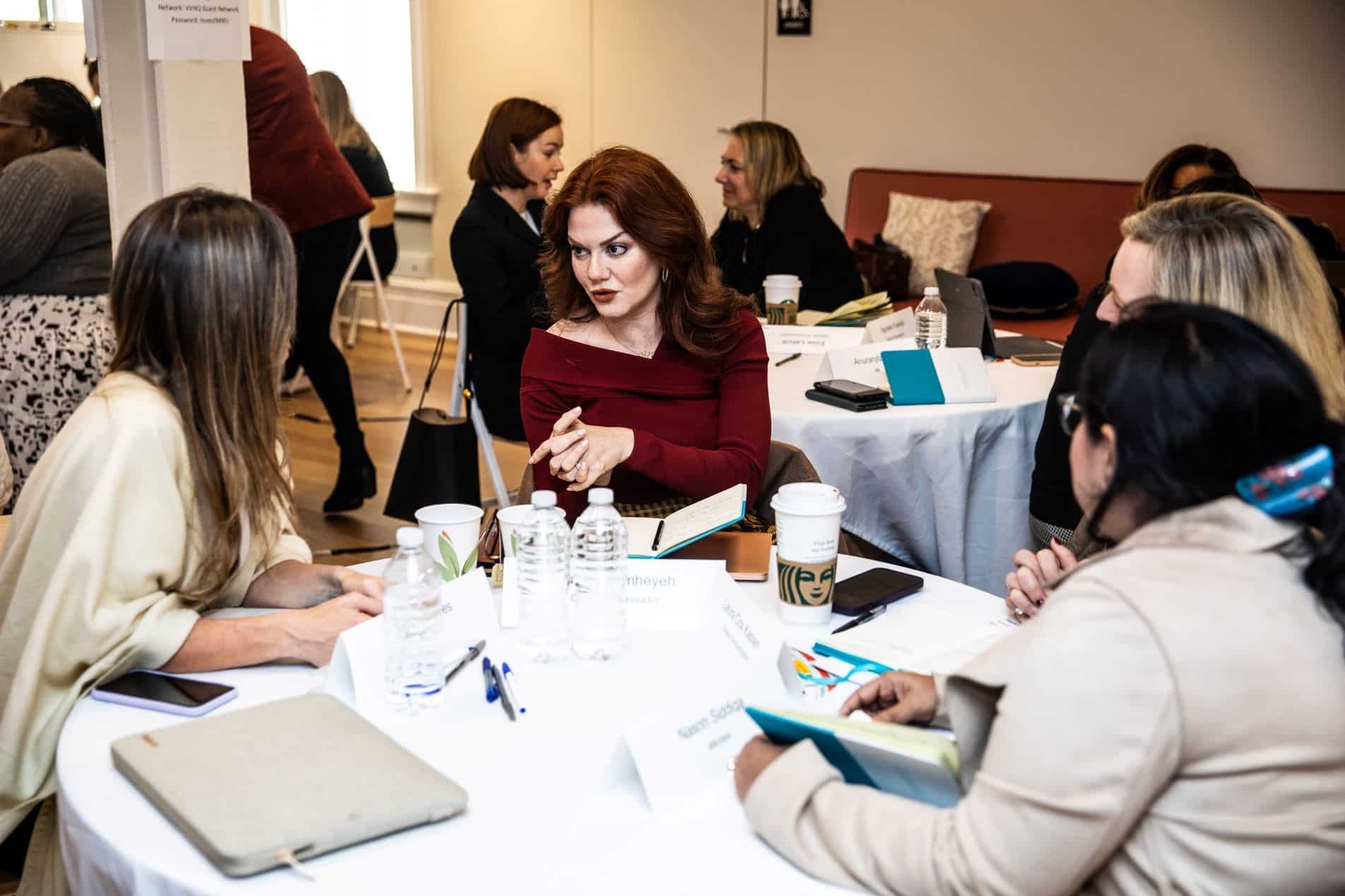 Rasha Qamheyeh seated at a table in discussion with women at the 2022 Global Ambassadors Program