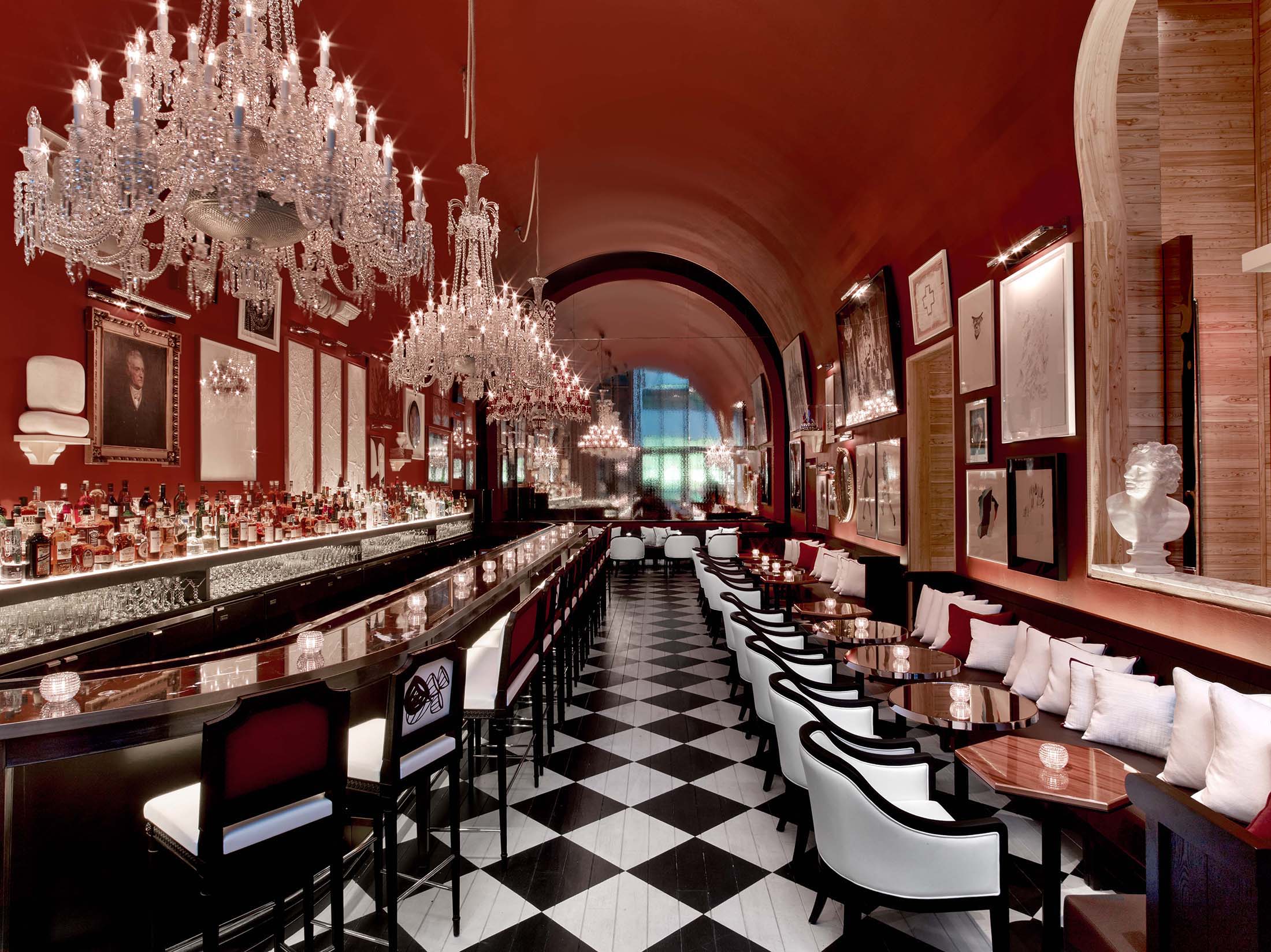 The bar at Baccarat Hotel New York, with red seating and crystal chandeliers