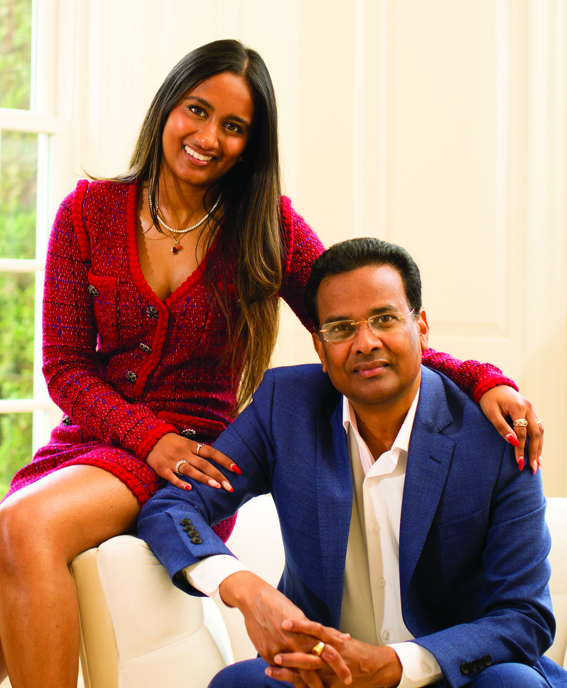 Pooja Ika beside her father Ravi Ika, who is seated in a blue suit