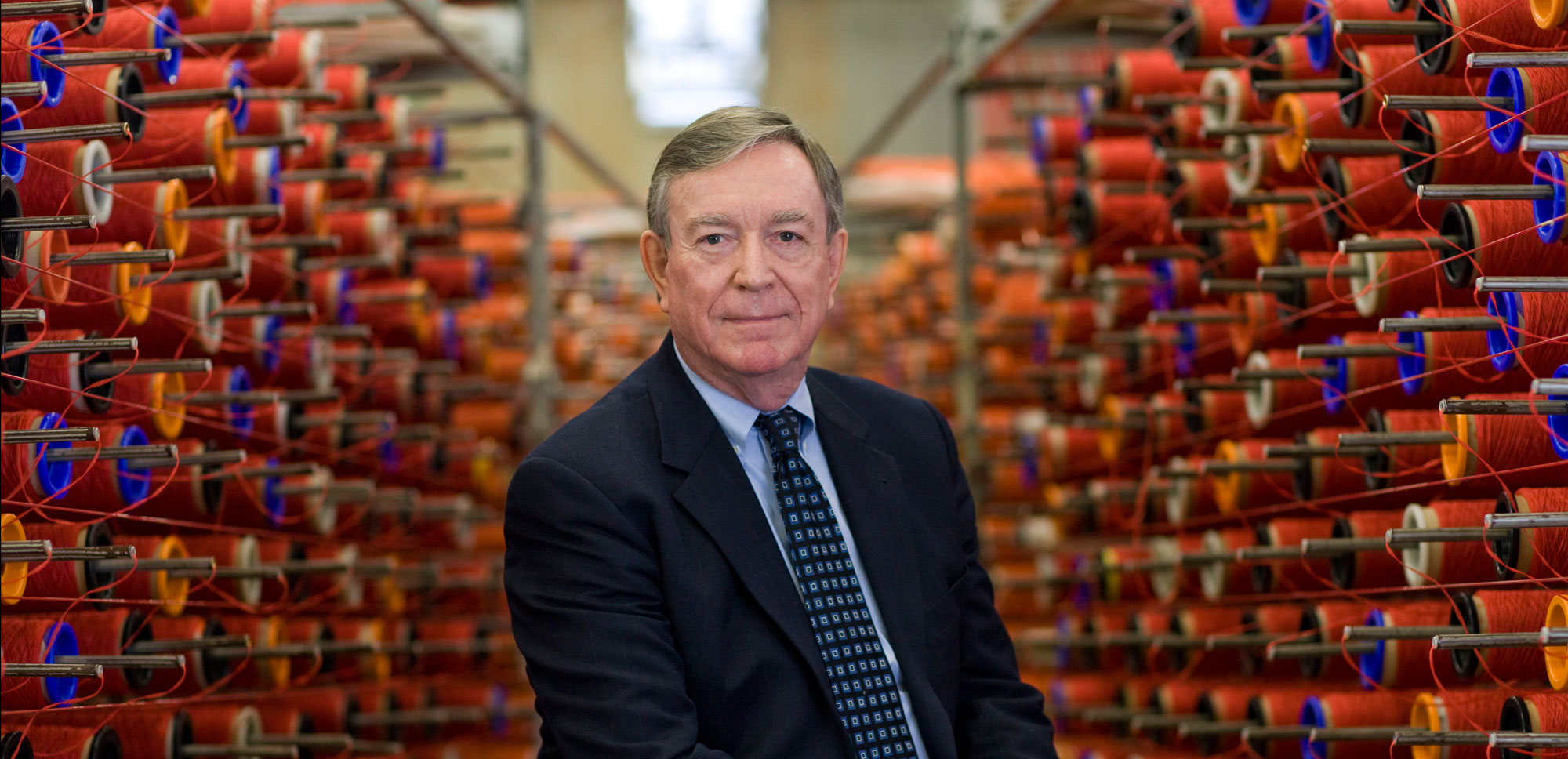 Ray C. Anderson among rows of red yarn at an Interface manufacturing facility