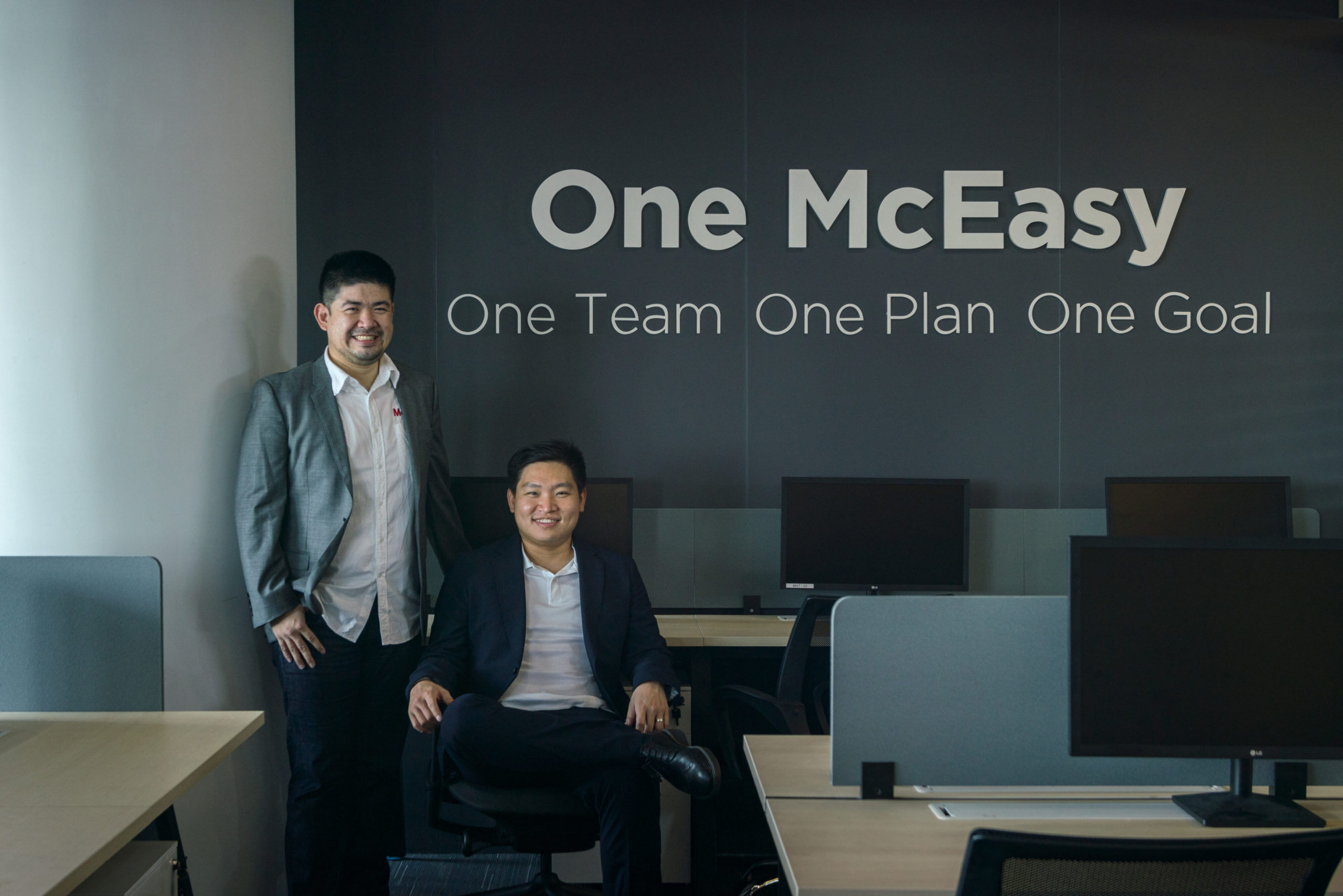 Hendrik Ekowaluyo standing beside Raymond Sutjiono, seated in a McEasy office