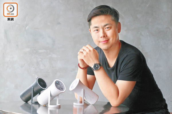 Raymond Wu seated at a table beside three WYND portable purifiers