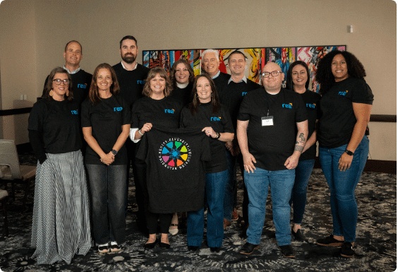 Rea colleagues in matching black shirts posing together at a gathering