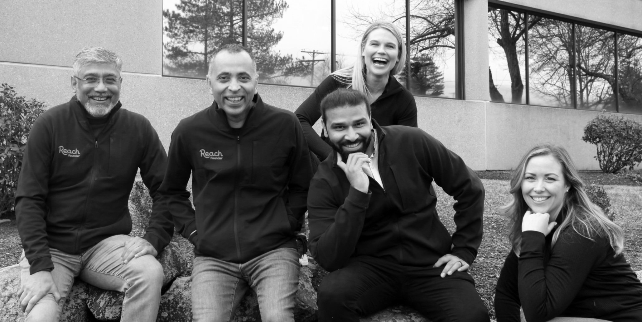 Five members of the Reach founding team outside an office building