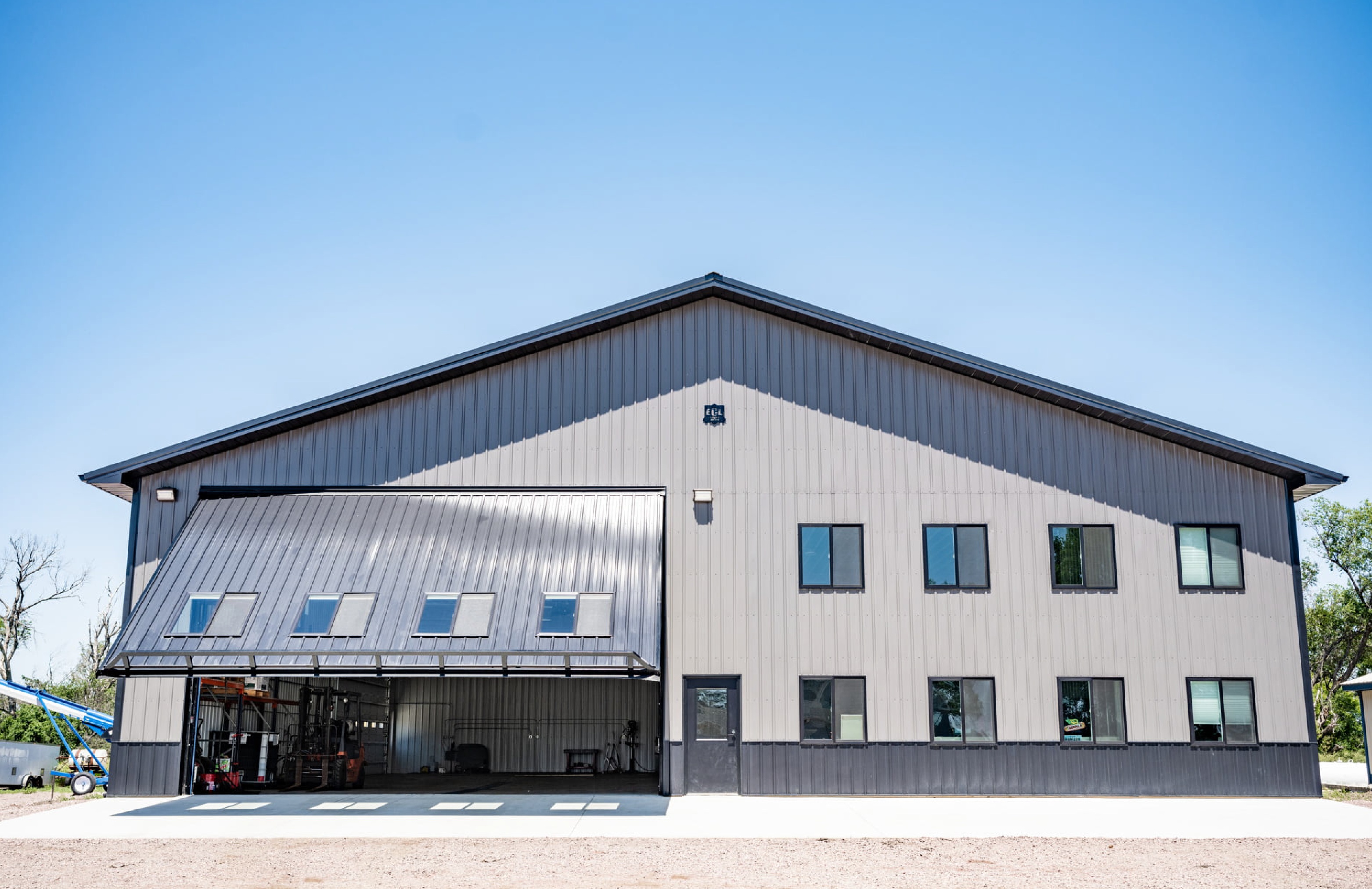 A large hydraulic door opening outward from a metal building, shown in LocaliQ’s PowerLift customer story