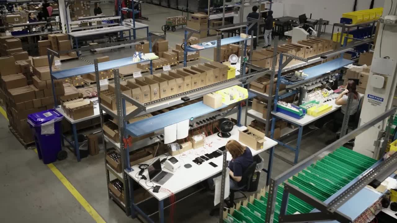 Rows of testing and packing workstations inside the Reagan Wireless warehouse