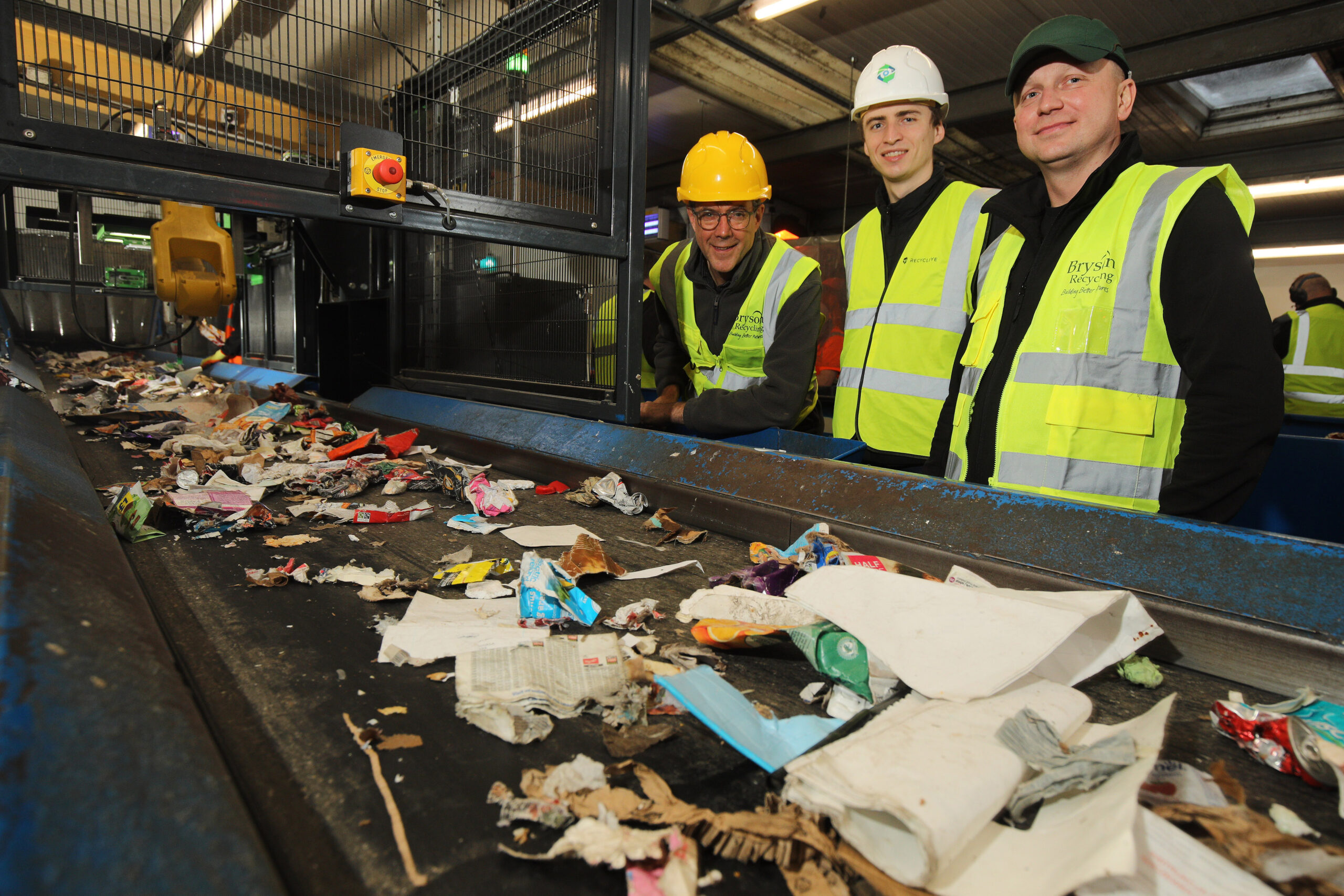 Recycleye and Bryson Recycling representatives standing beside an installed sorting robot