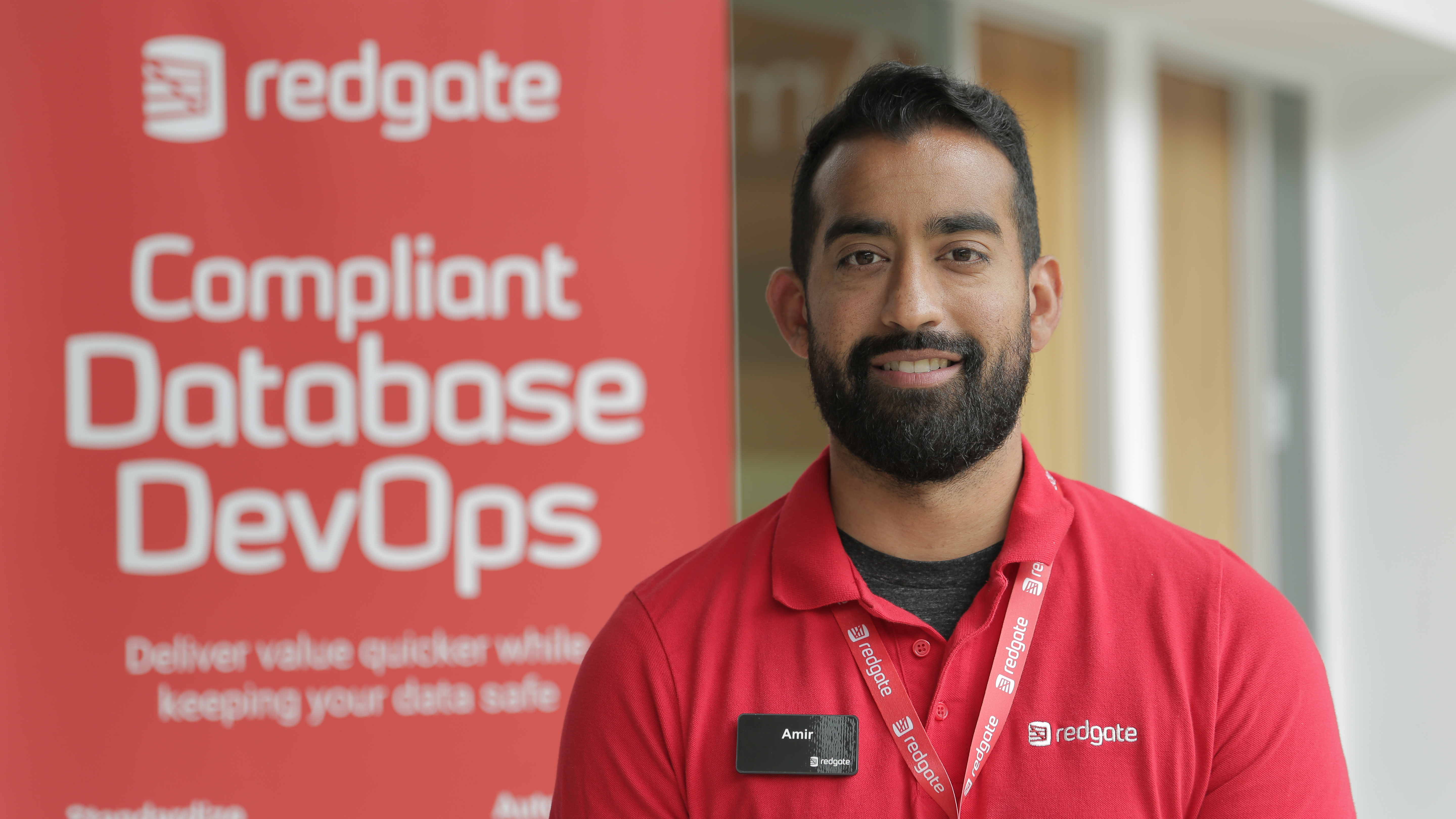 A Redgate staff member beside a Database DevOps display