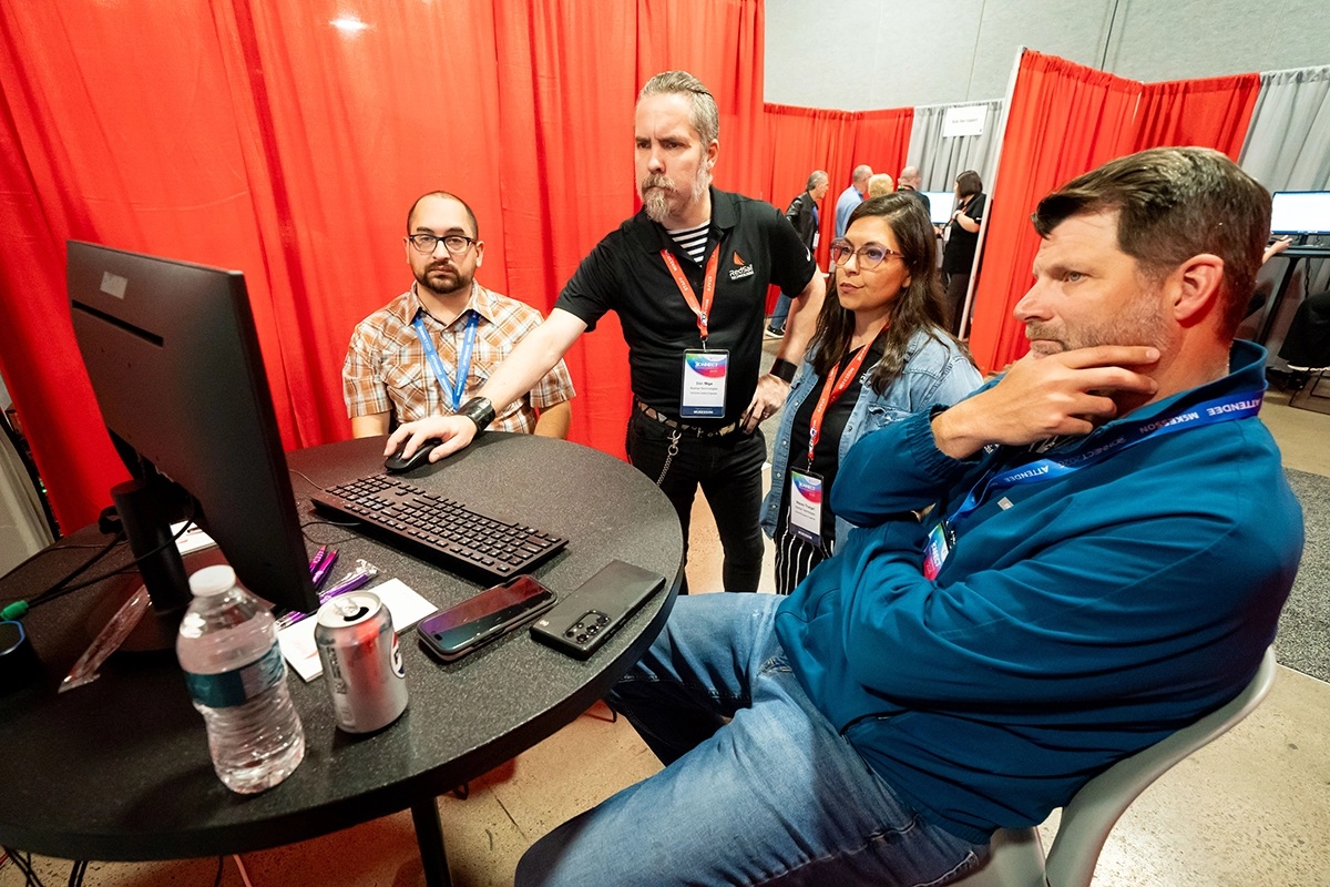 Connect 2026 attendees watching a pharmacy software demonstration at an exhibition booth