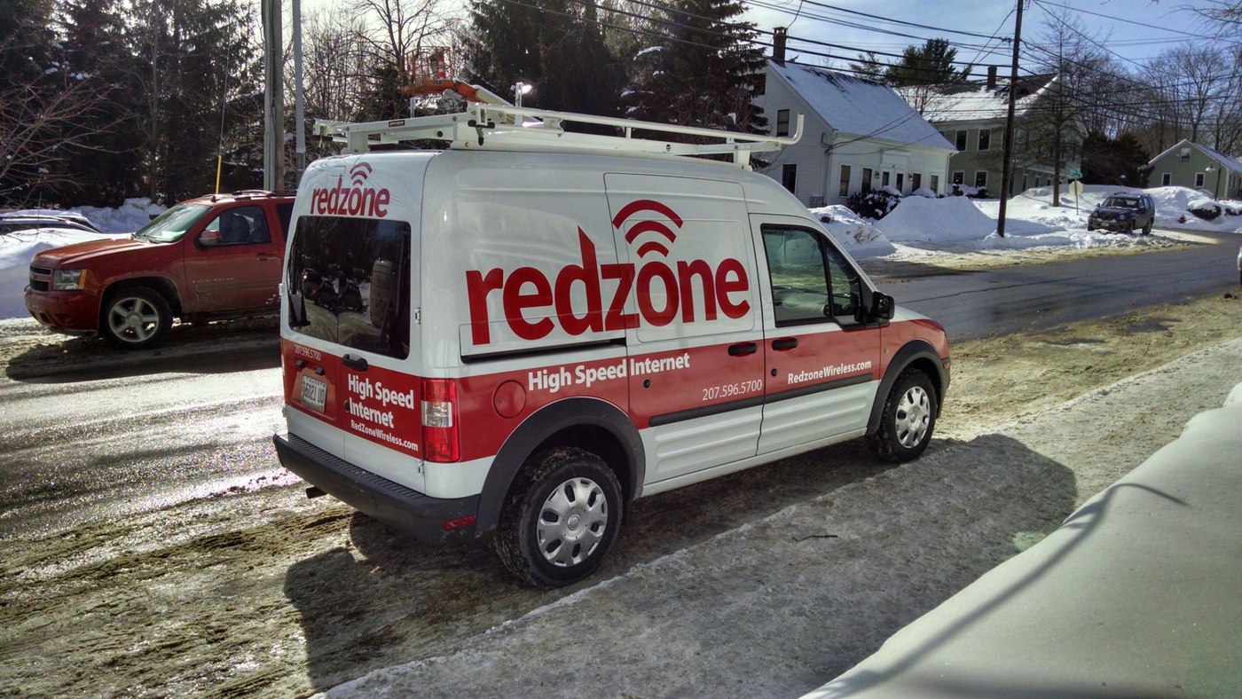 A Redzone Wireless service van parked on a snowy Maine street