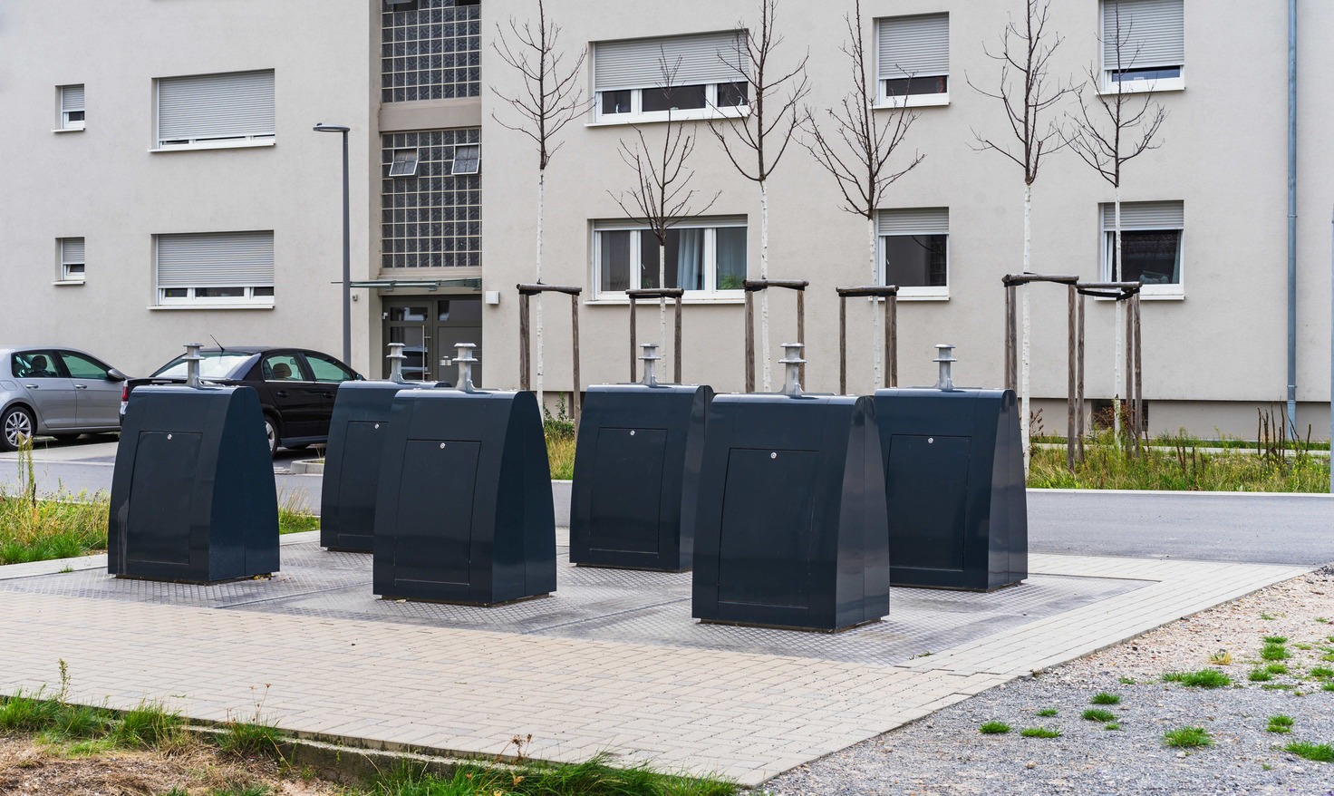 Dark waste containers arranged outside a residential building