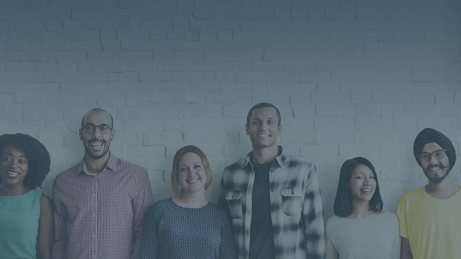 A diverse group of professionals standing together against a brick wall