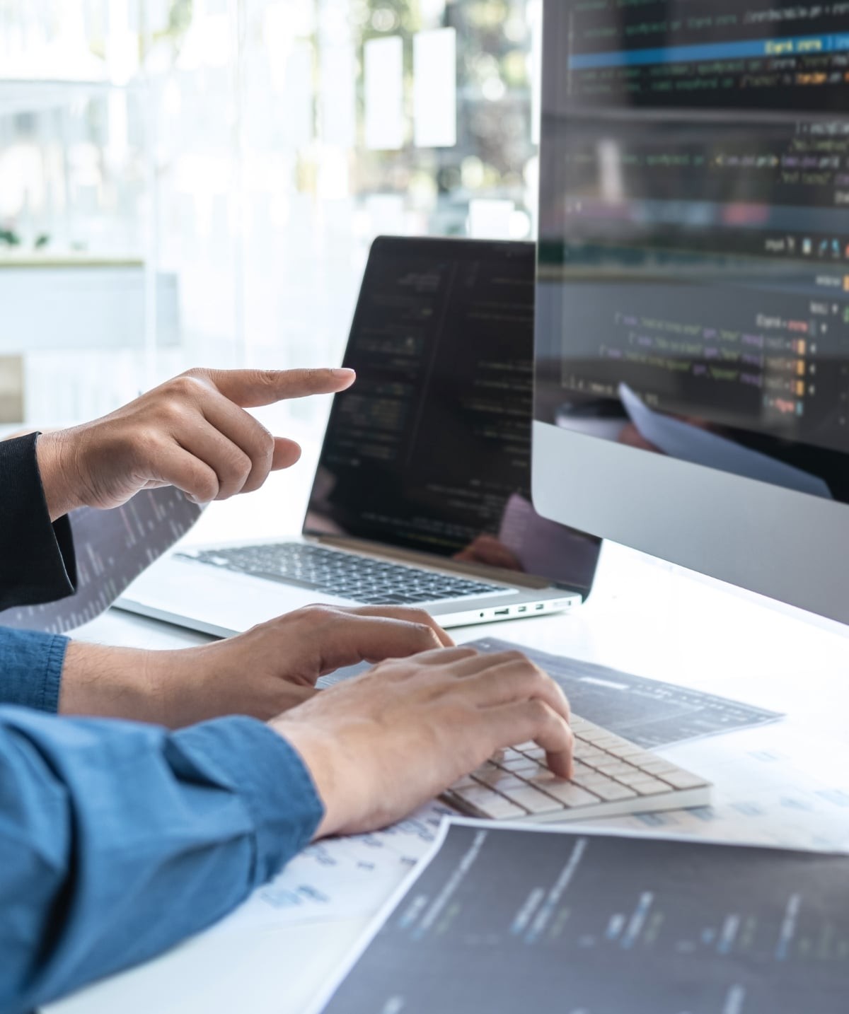 A person working across several computer screens, representing enterprise software integration