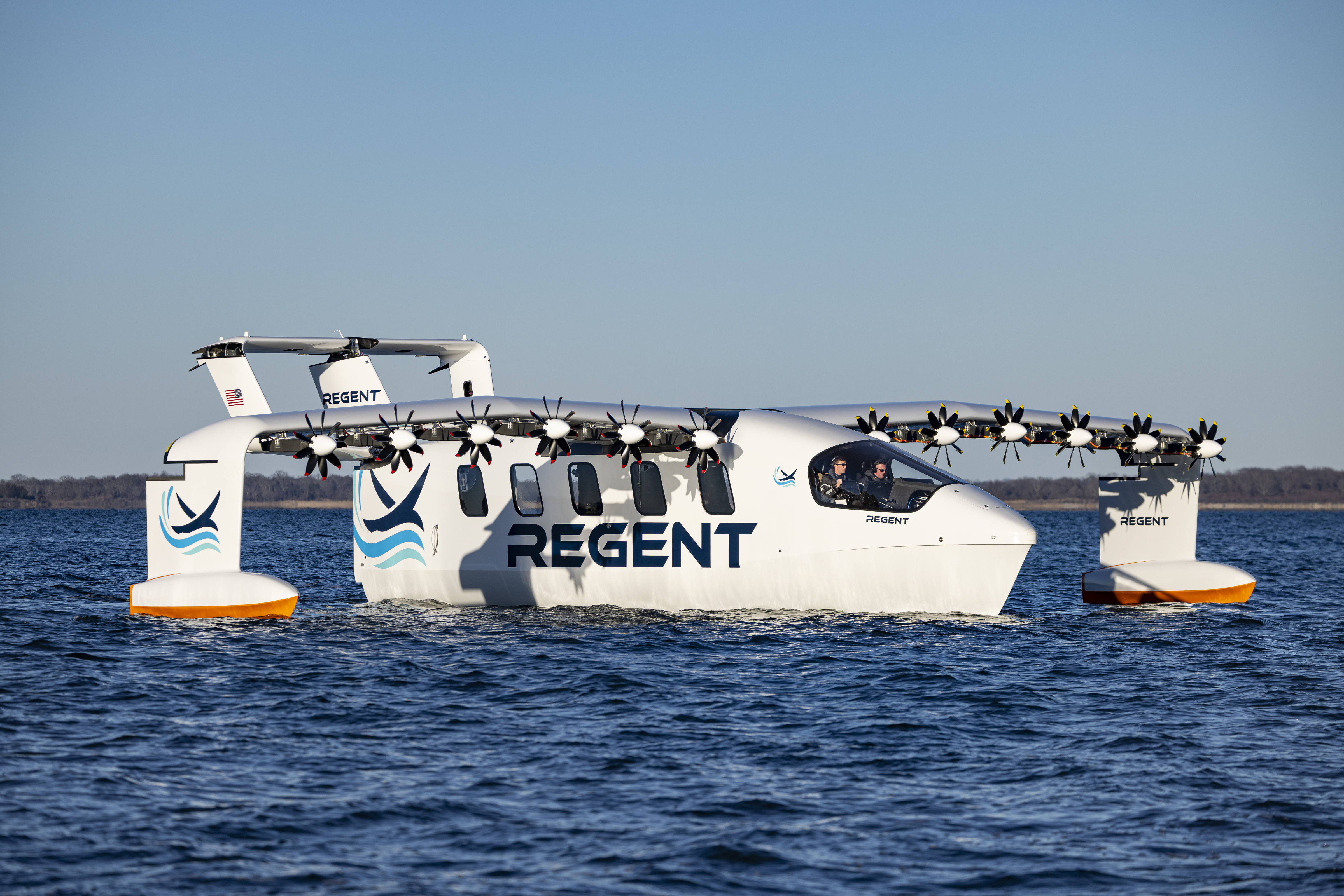 REGENT’s full-scale white Viceroy prototype floating on Narragansett Bay, with twelve propellers across its wing