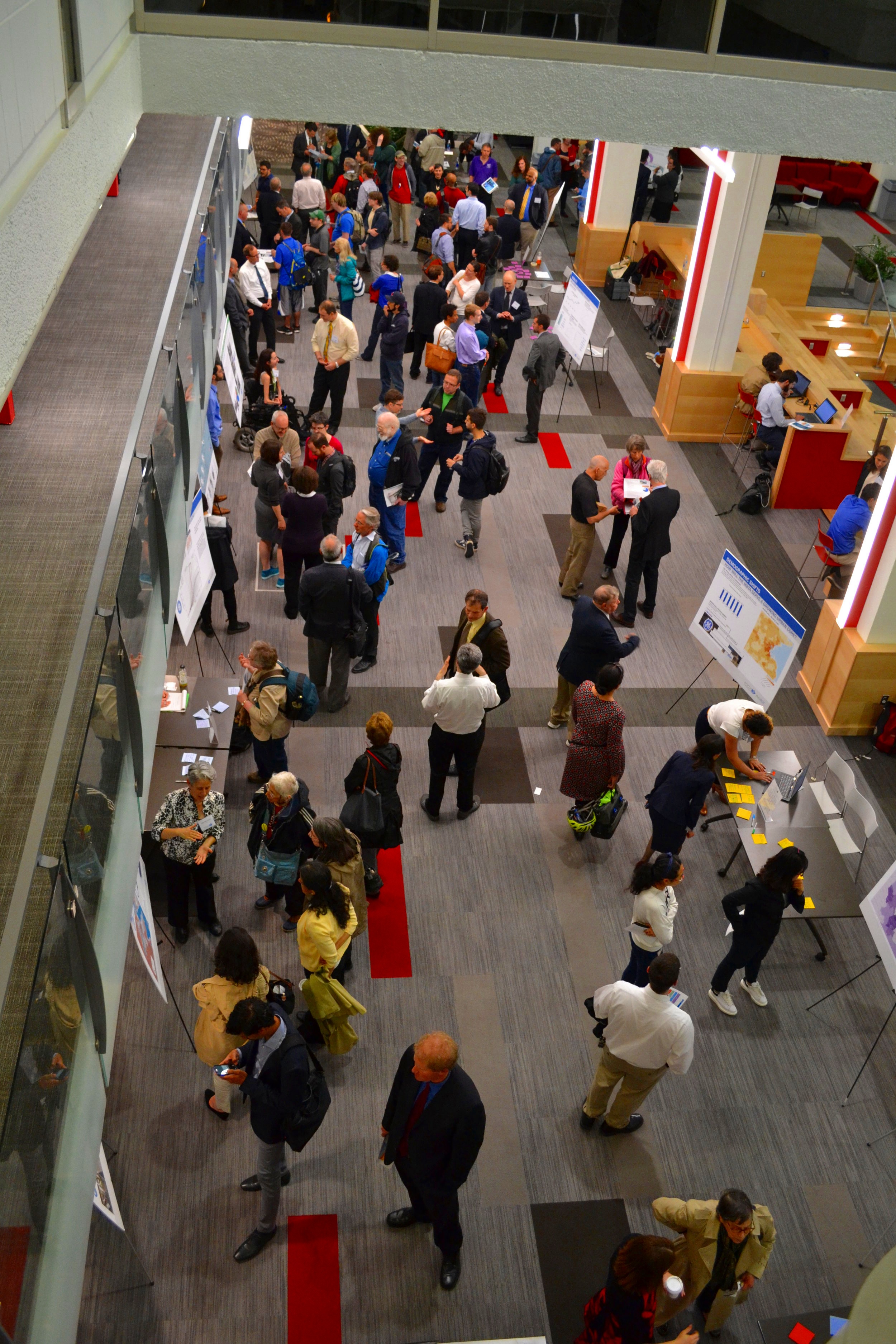 An overhead view of a crowded Focus40 public open house with people gathered around presentation boards
