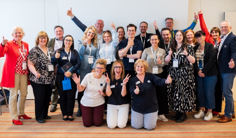 A group of RAPS community participants smiling and giving thumbs-up
