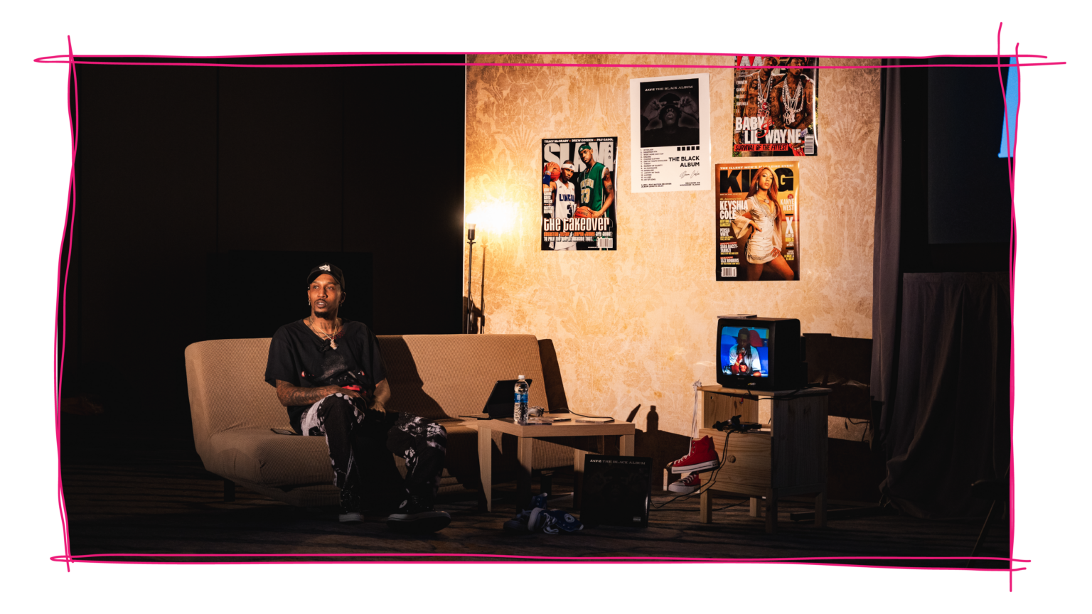 Brandon Jennings seated on a couch within a living-room stage set at the NBA Rising Stars engagement