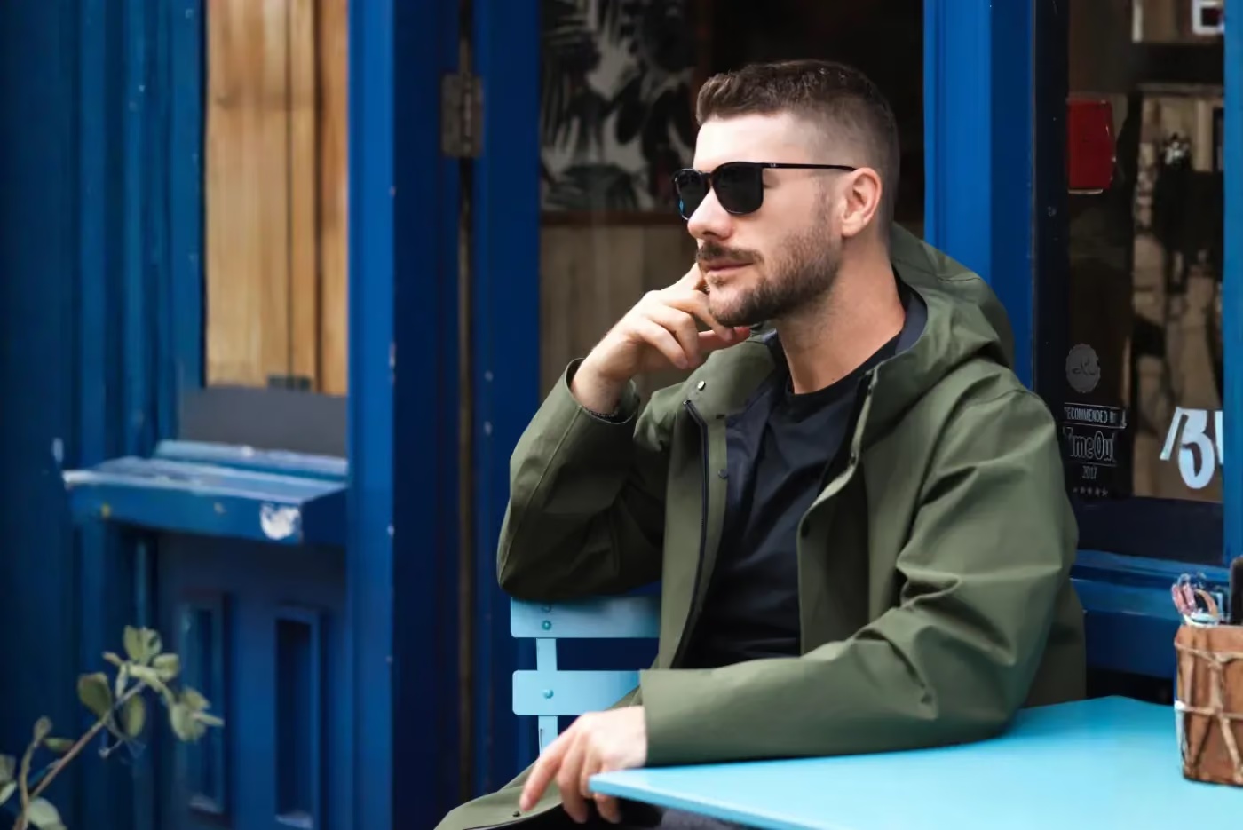 Relogate co-founder Roman Tsuper seated outside beside a blue storefront