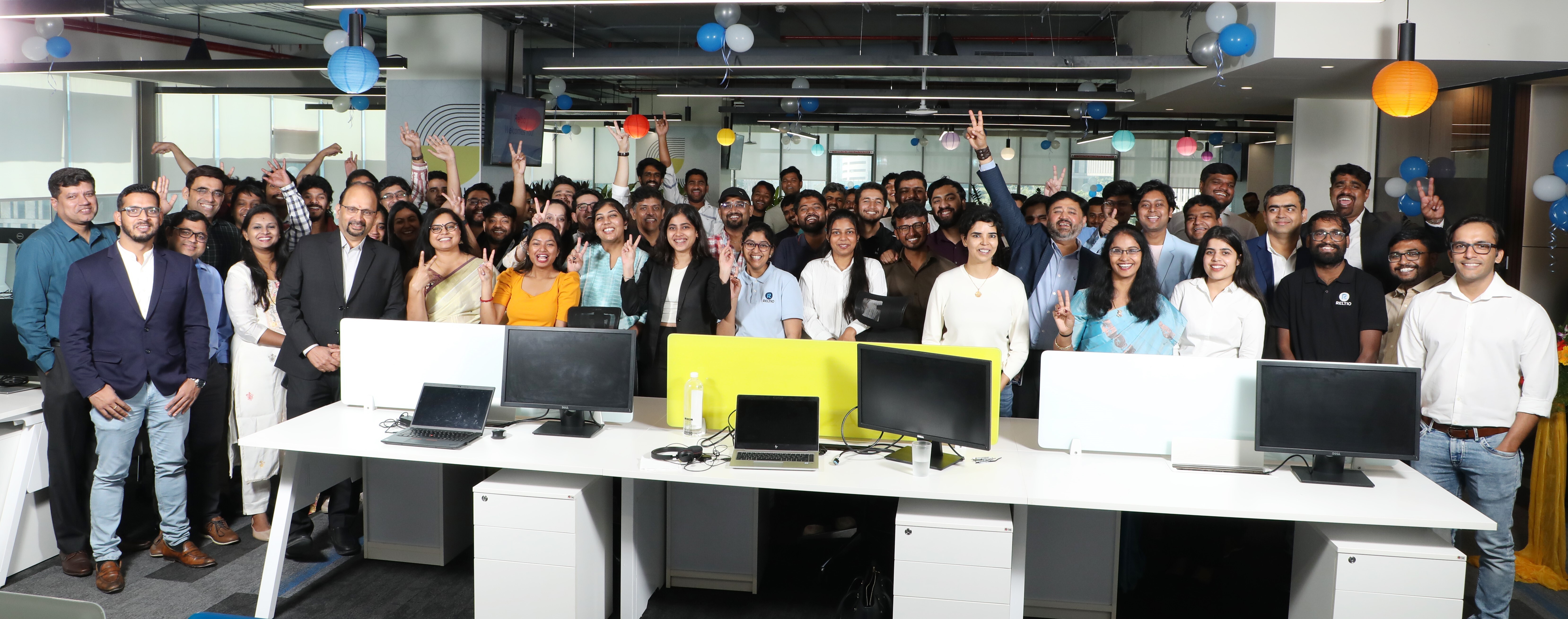 A large group of Reltio employees gathered in an office