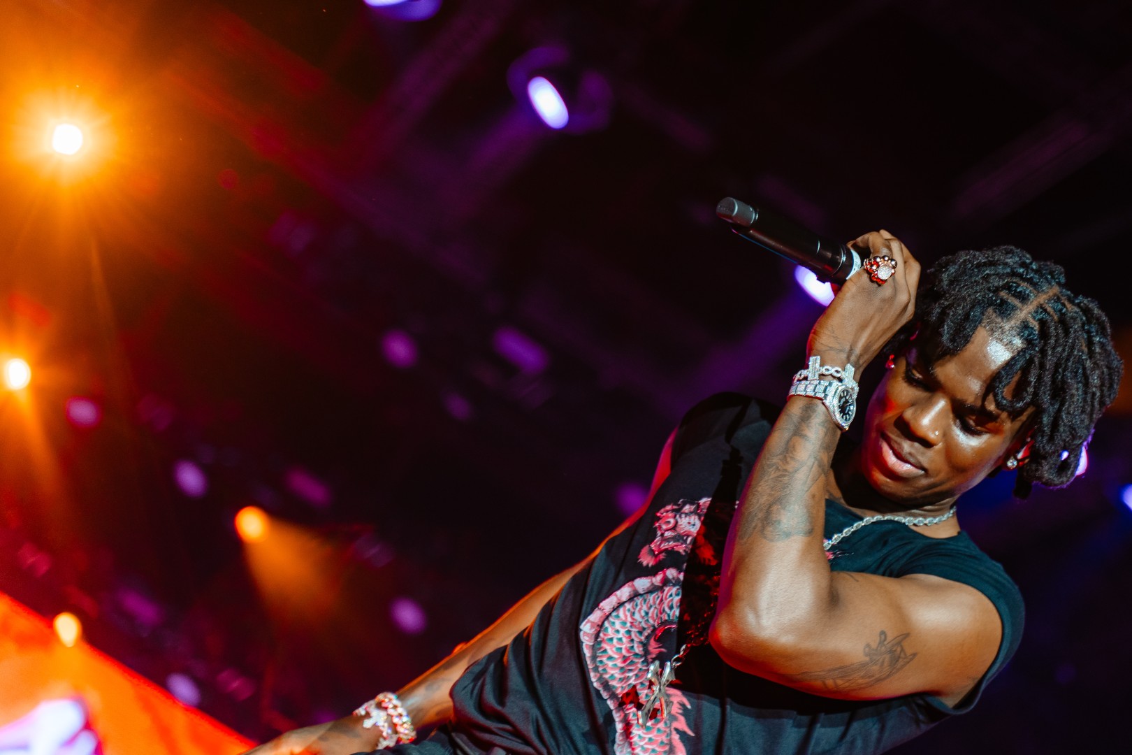 Rema performing under red and blue stage lights at Electric Castle in Romania in July 2024