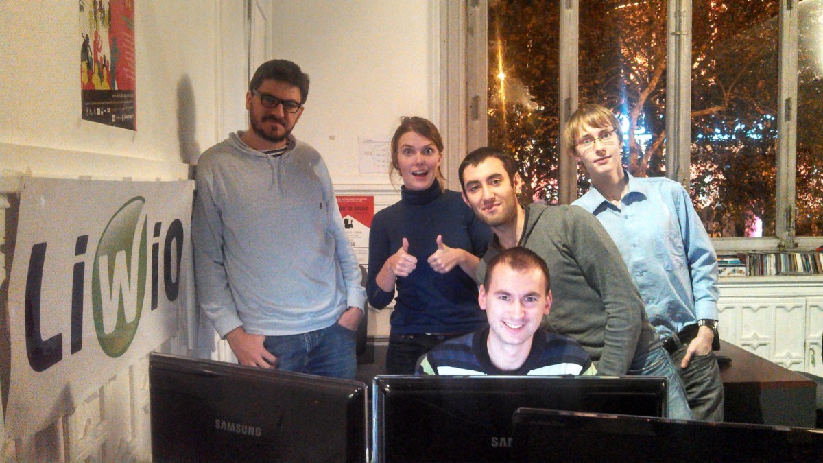 Early Liwio and AB Tasty colleagues gathered behind computer monitors in a small office