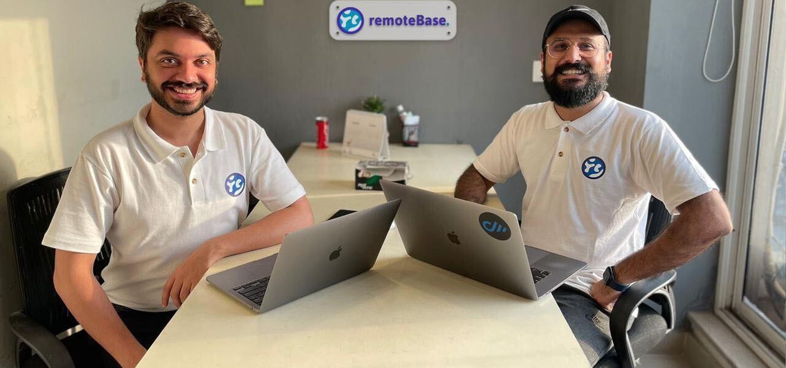 Remotebase co-founders Qasim Asad Salam and Talha Masood seated with laptops in their Lahore office