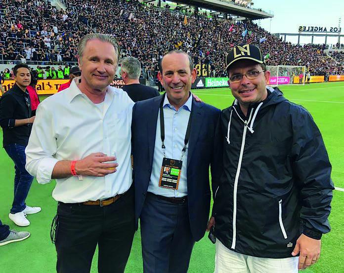 René van de Zande, Don Garber and Roberto Silva standing beside a football pitch in a crowded Los Angeles stadium