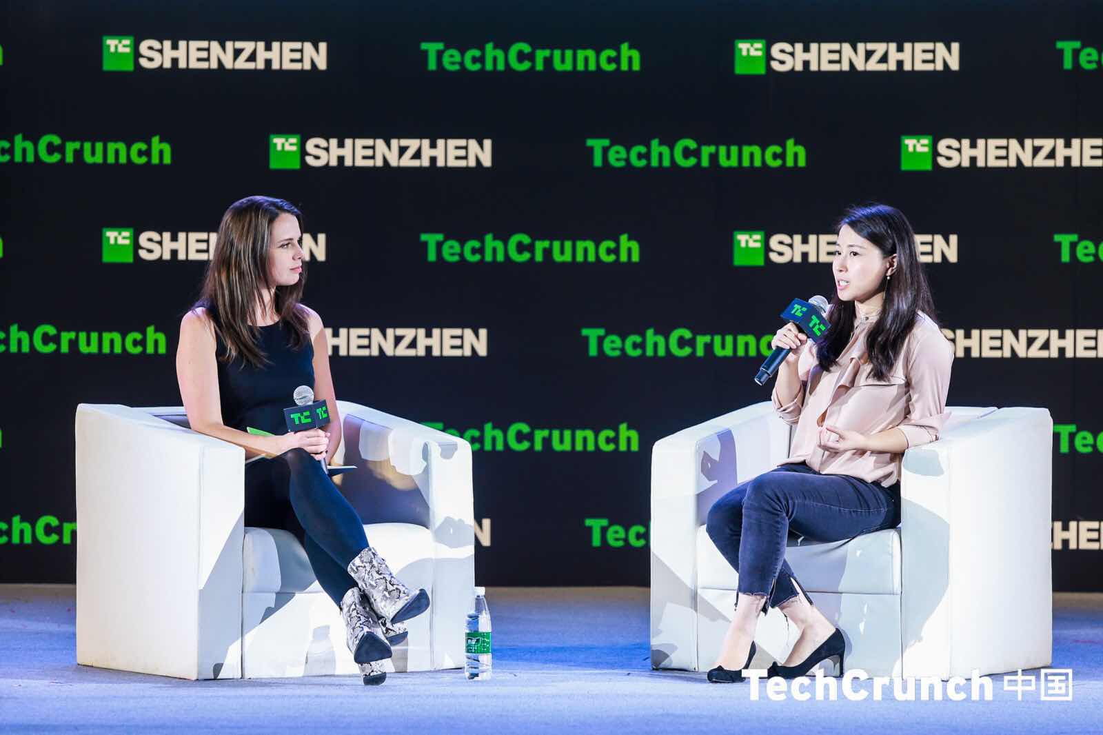 Renee Wang, seated at right, speaks into a microphone during a TechCrunch Shenzhen discussion.