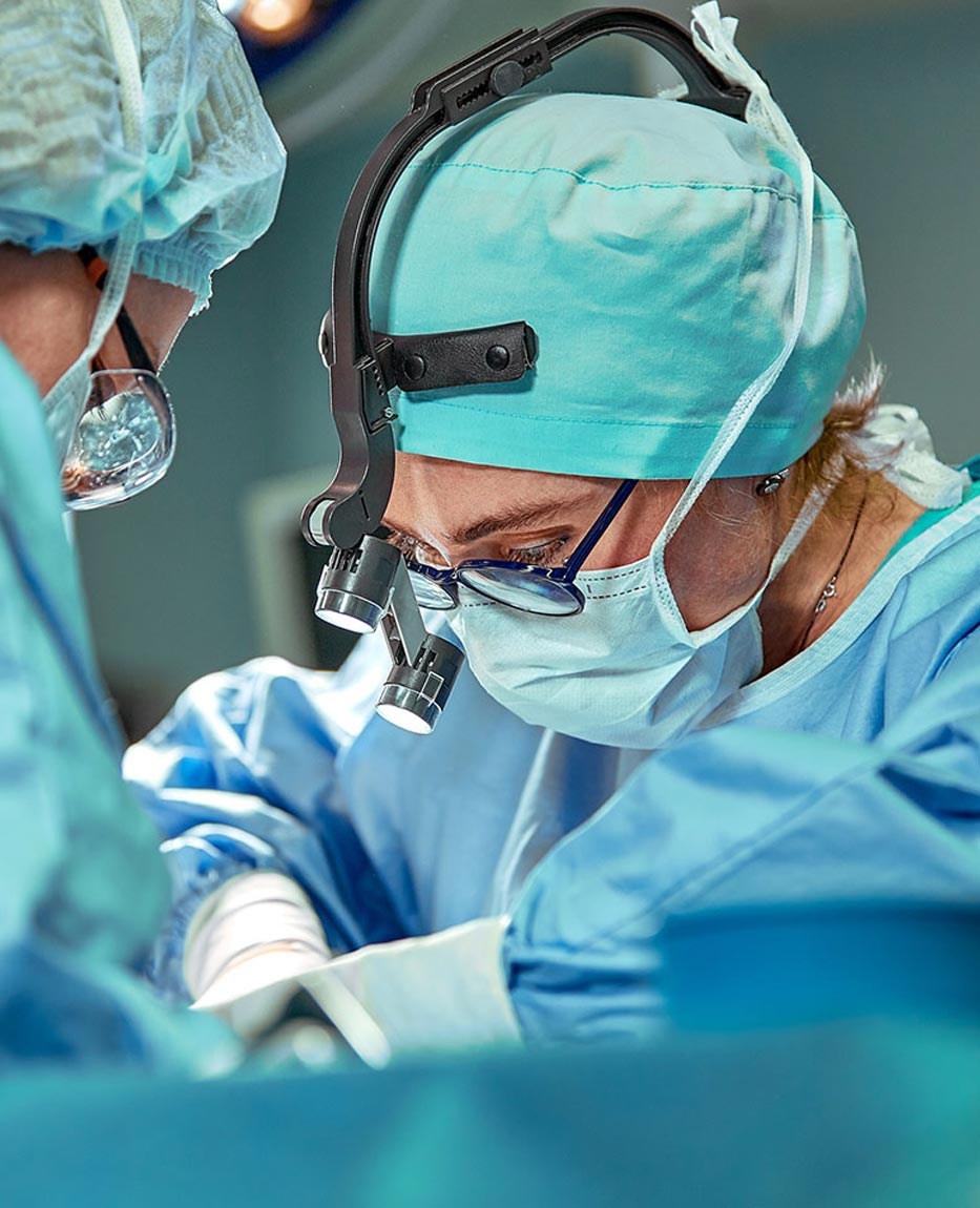 Masked surgical clinicians working under magnifying optics