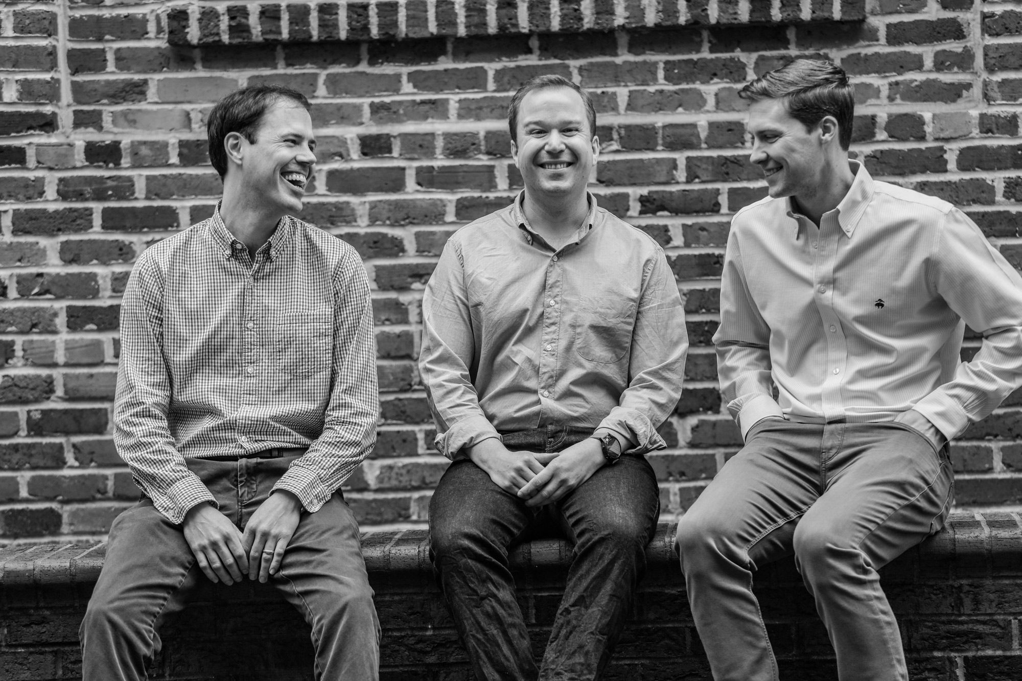 Rent Ready founders Will Brugh, Jonathan Kite, and Ryan McMillan sitting together against a brick wall