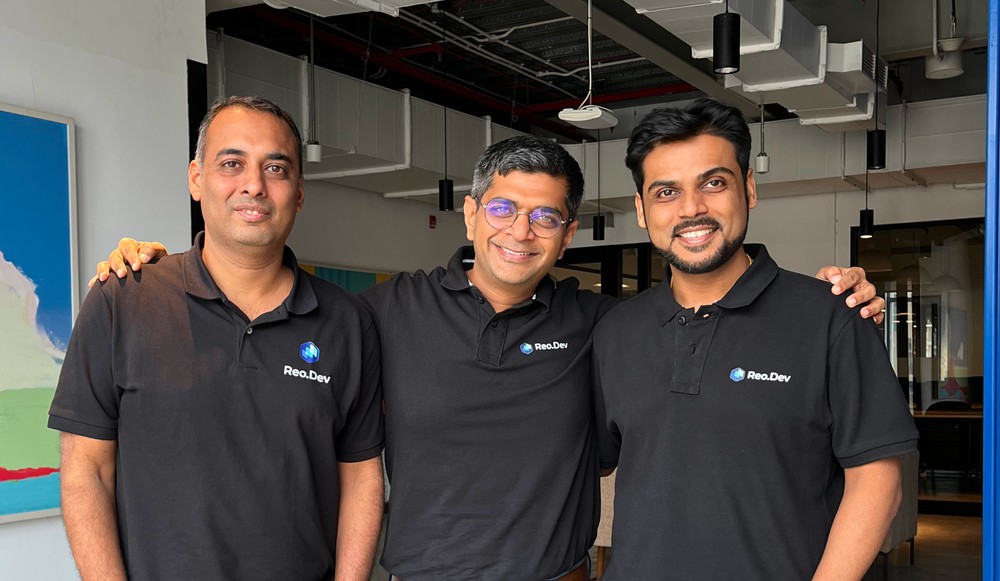 Reo.Dev co-founders Gaurav Jain, Achintya Gupta and Piyush Agarwal standing together in company shirts